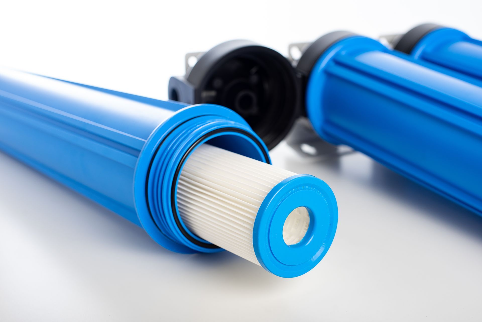 Blue filter cartridges with white pleated cores on a white background