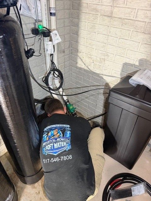 Technician servicing a whole home water softener tank in a basement