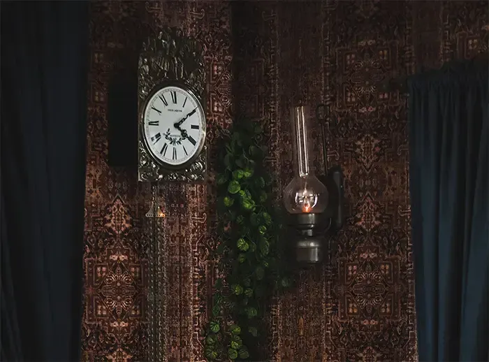 Er hangt een klok aan de muur naast een lamp in Villa BreTil.