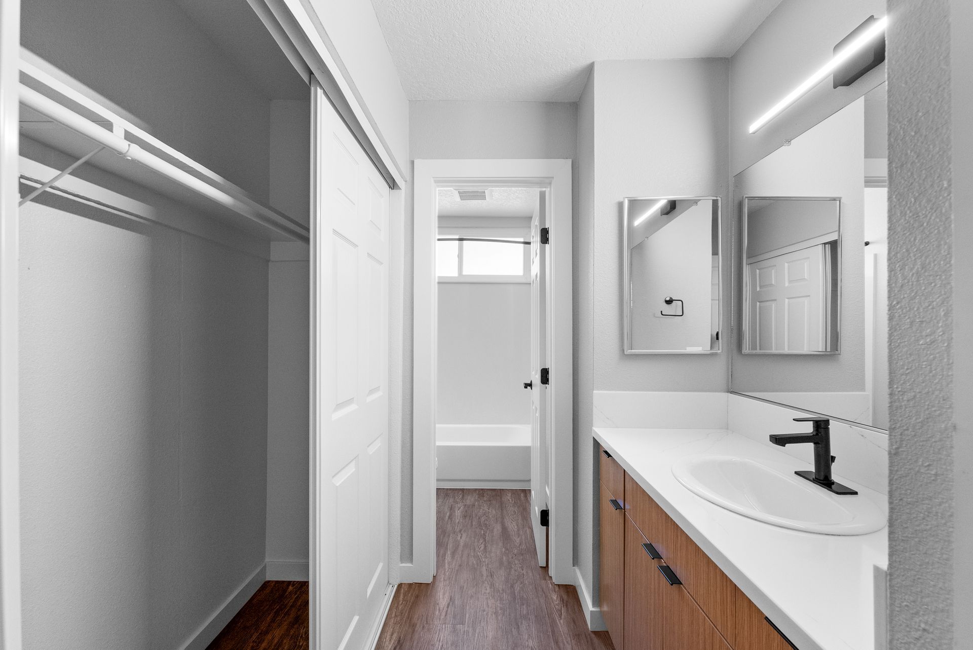 Hallway with closet on left and sink with mirror on right
