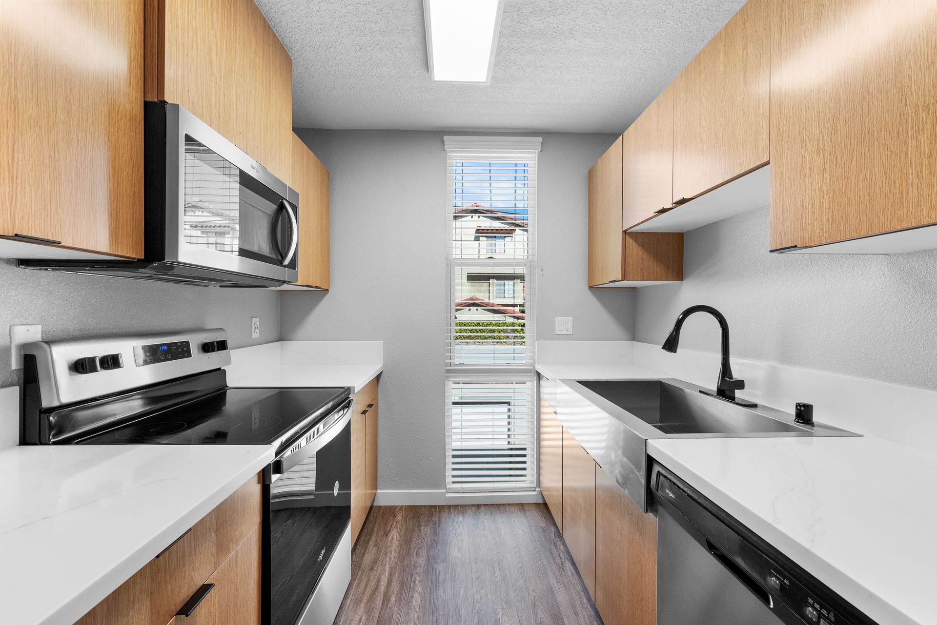 Kitchen with window, sink, dishwasher, microwave, and stove