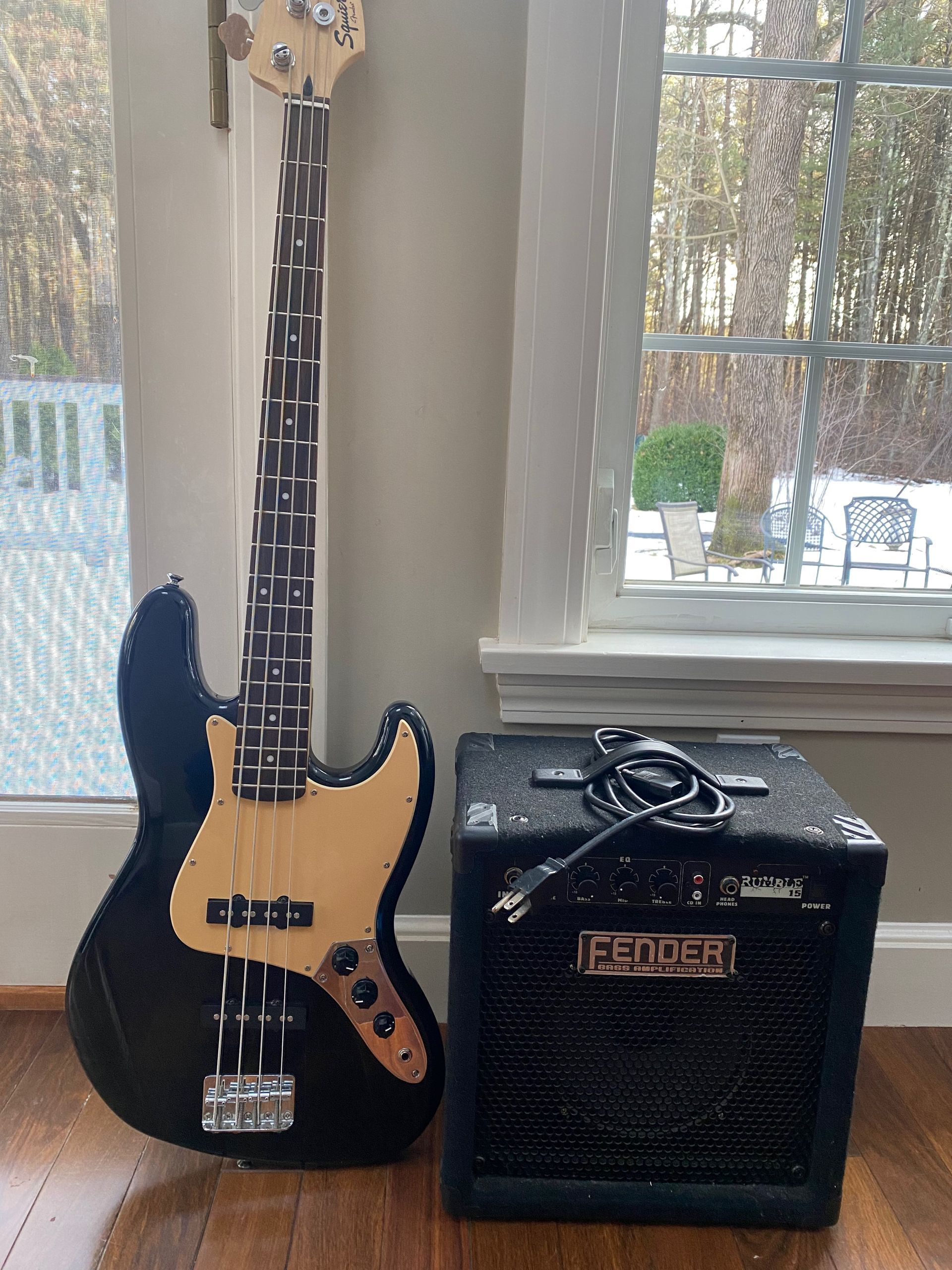 a black electric guitar and an amplifier