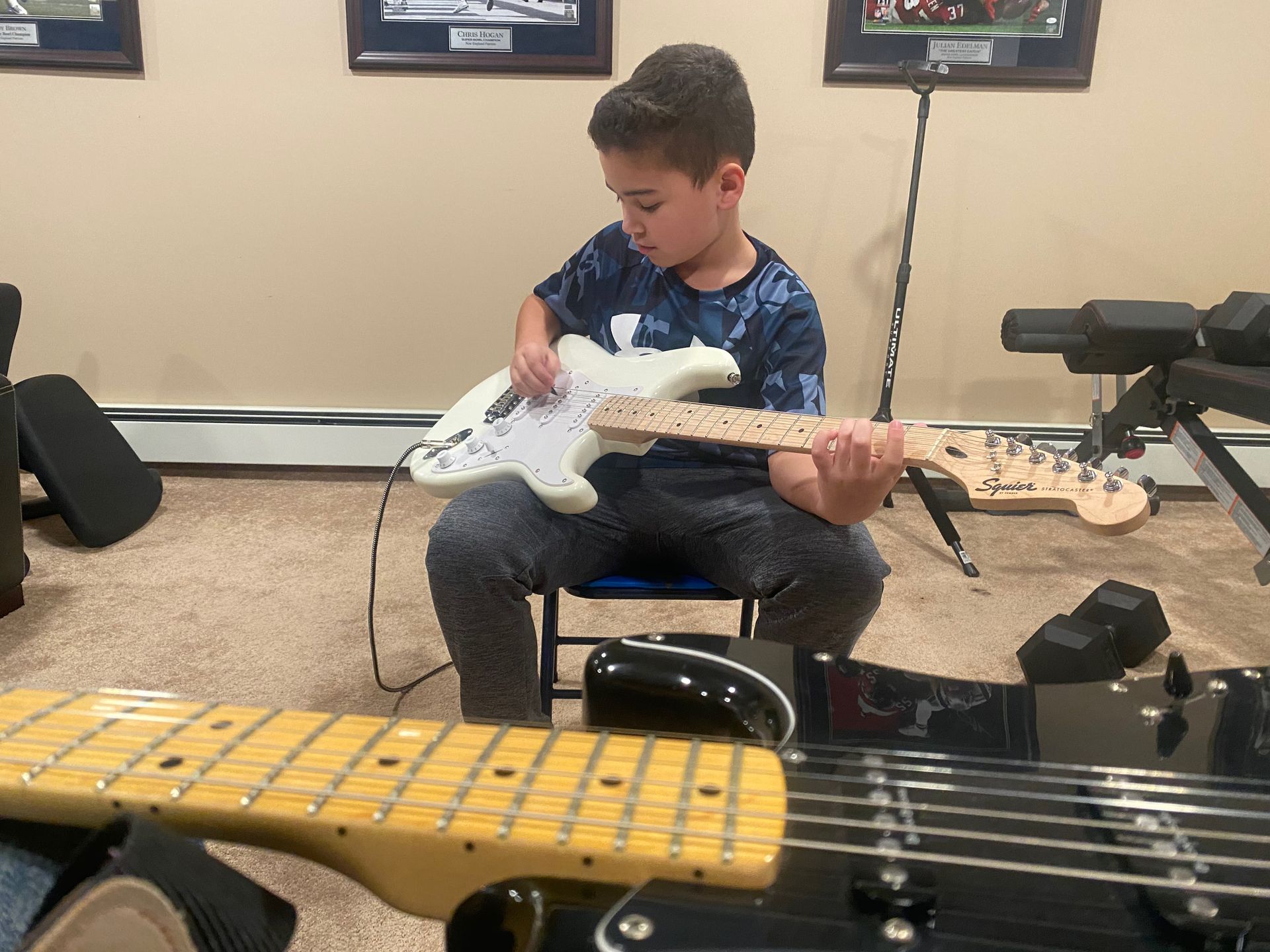 kid testing out a electric guitar in a practice room