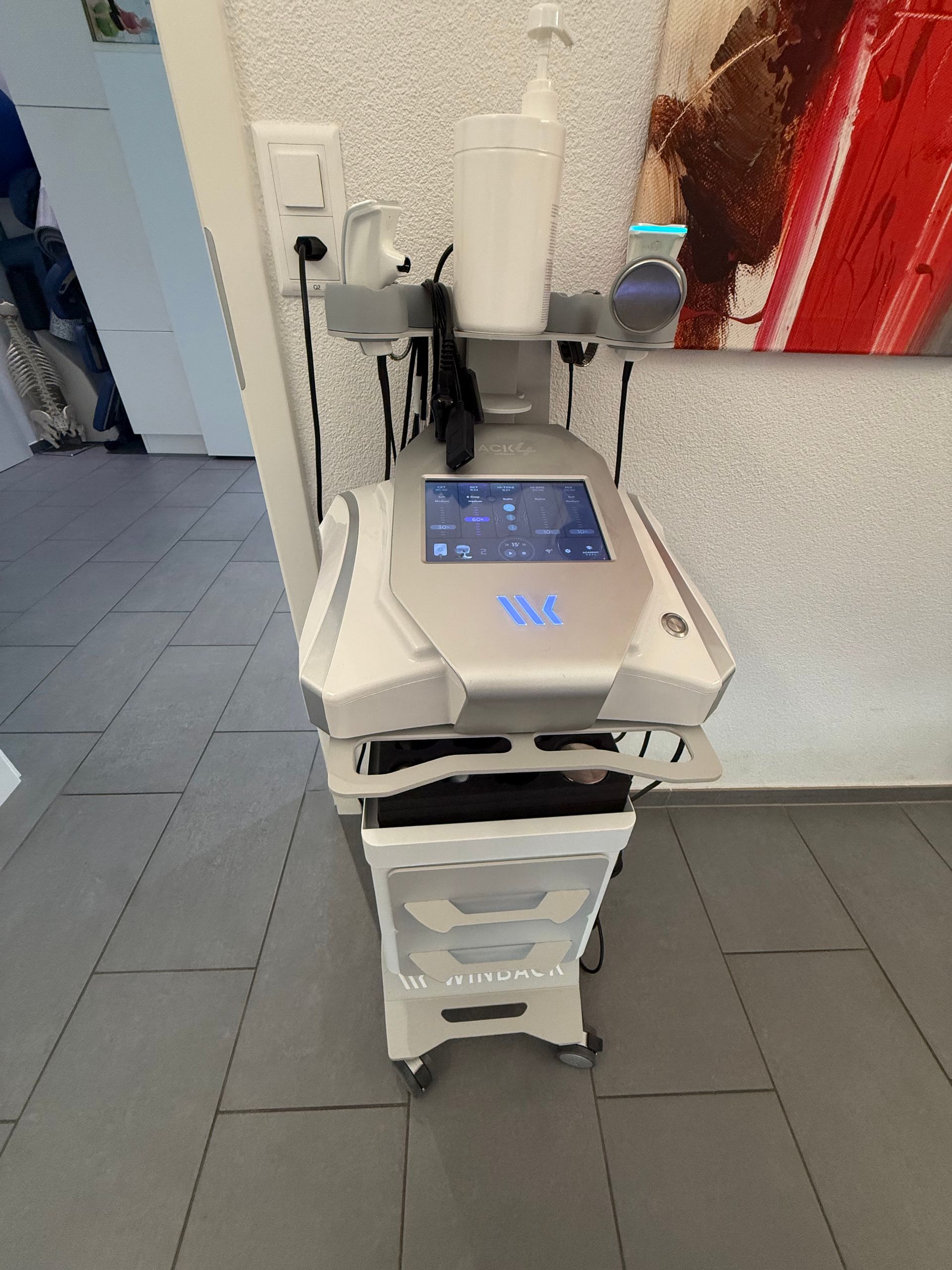 Dispositif médical blanc avec écran tactile et affichage dans une salle de clinique carrelée