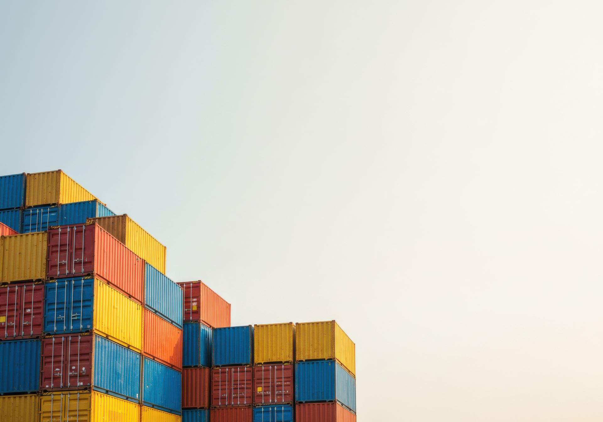 A subway train is pulling into a station with a city skyline in the background.