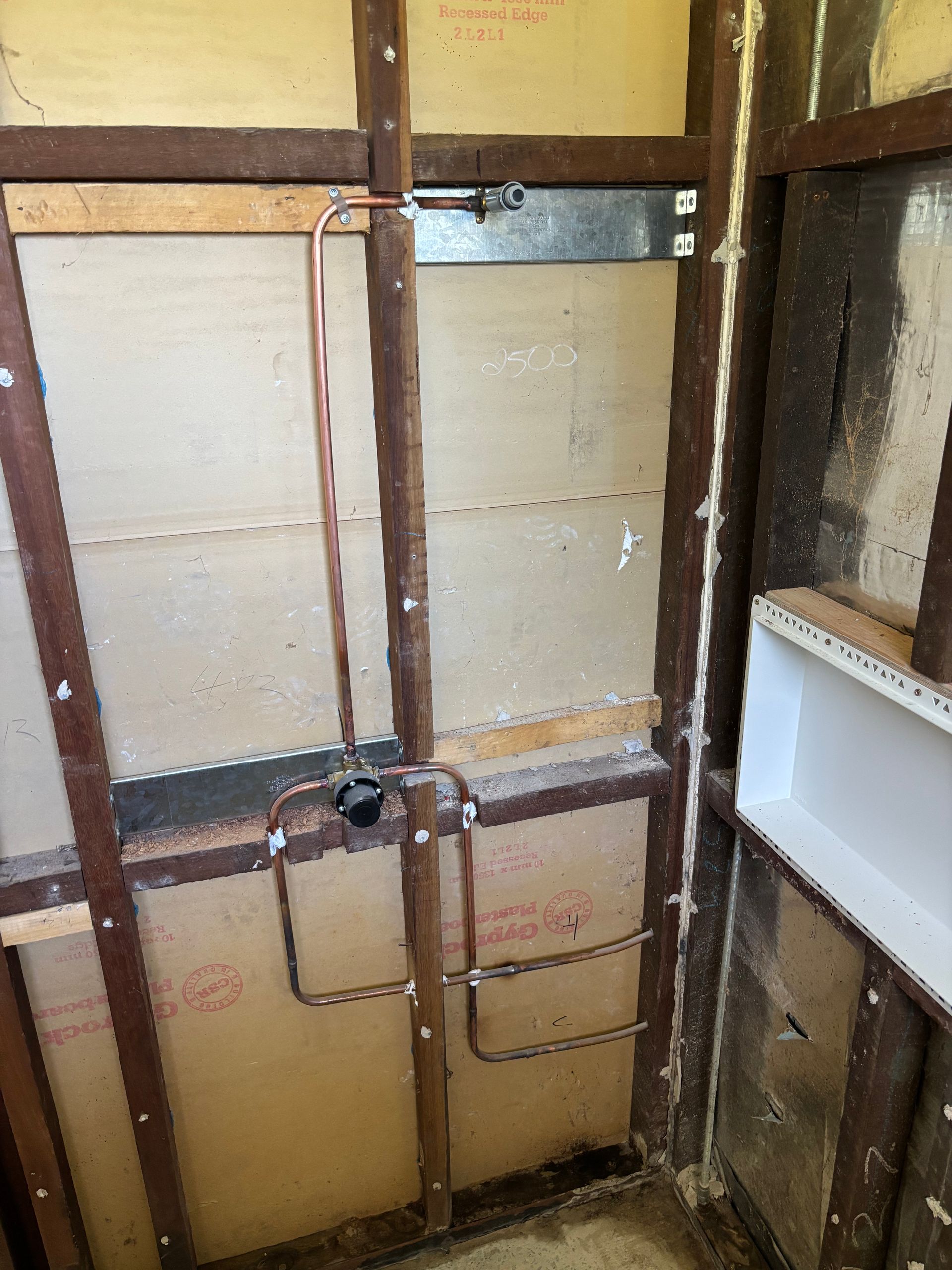 Exposed wall framing with plumbing and electrical cutouts — Truflow Plumbing & Gas Solutions in Rockhampton City, QLD