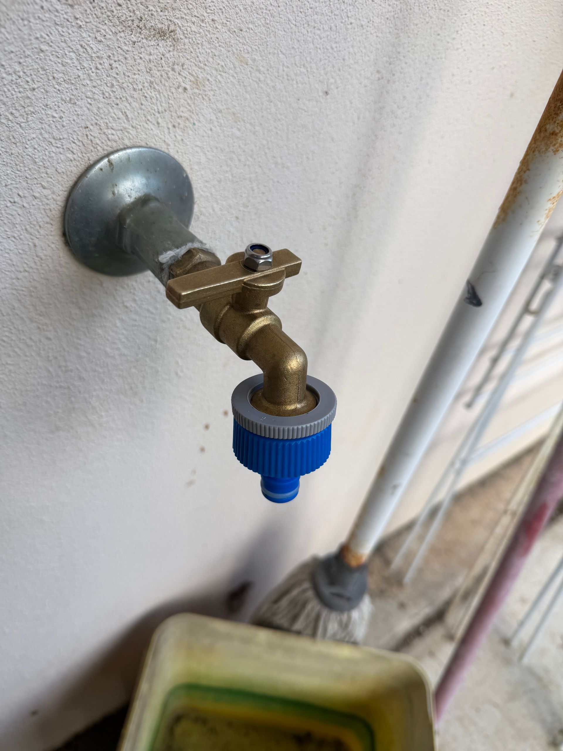 Outdoor brass faucet with a blue hose nozzle mounted on a wall — Truflow Plumbing & Gas Solutions in Rockhampton City, QLD