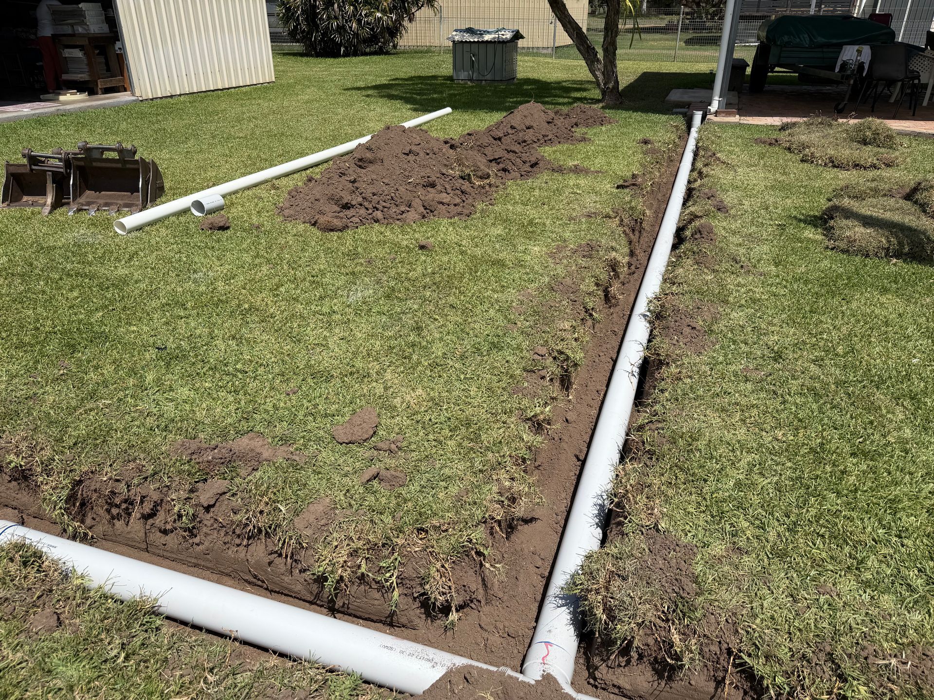 PVC pipes forming a border around a grassy yard — Truflow Plumbing & Gas Solutions in Rockhampton City, QLD