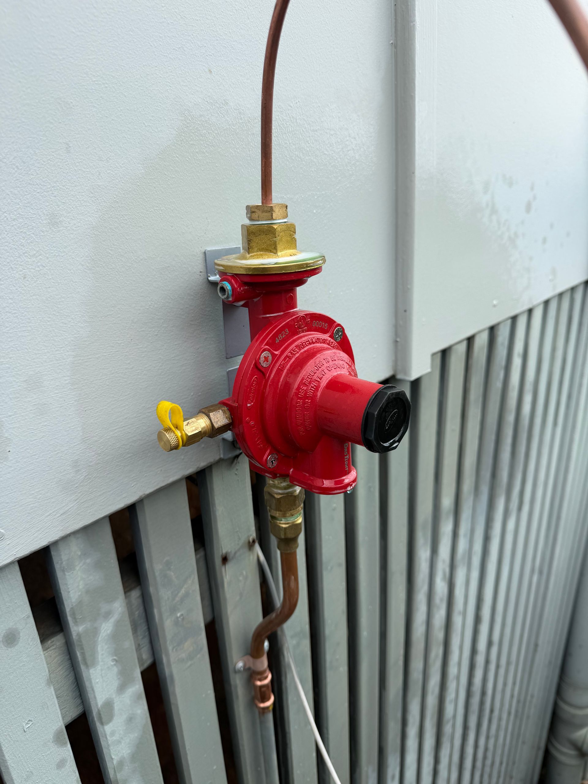 Red fire sprinkler valve and piping mounted on a wall — Truflow Plumbing & Gas Solutions in Rockhampton City, QLD