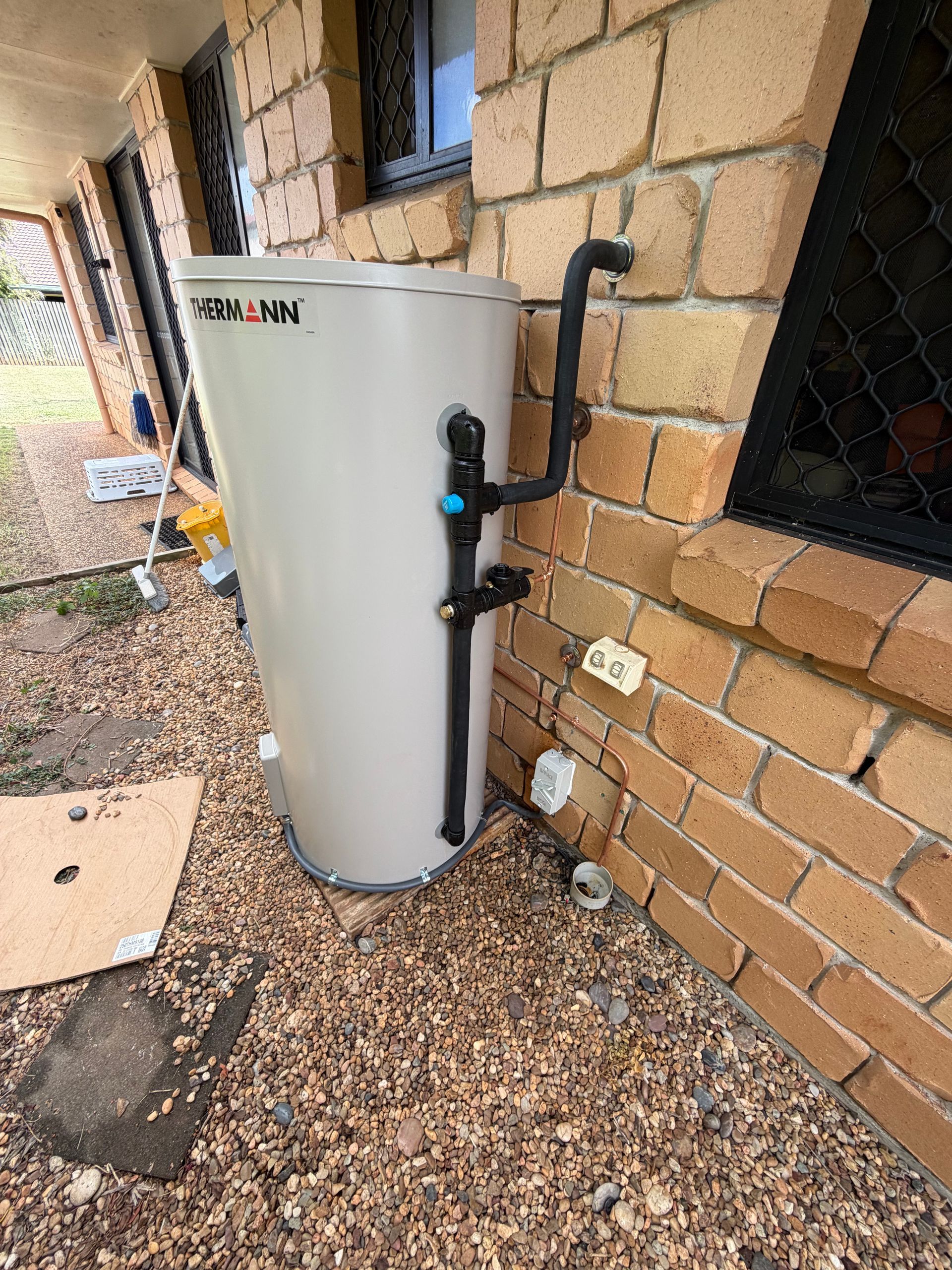 White outdoor water heater against a brick wall — Truflow Plumbing & Gas Solutions in Rockhampton City, QLD