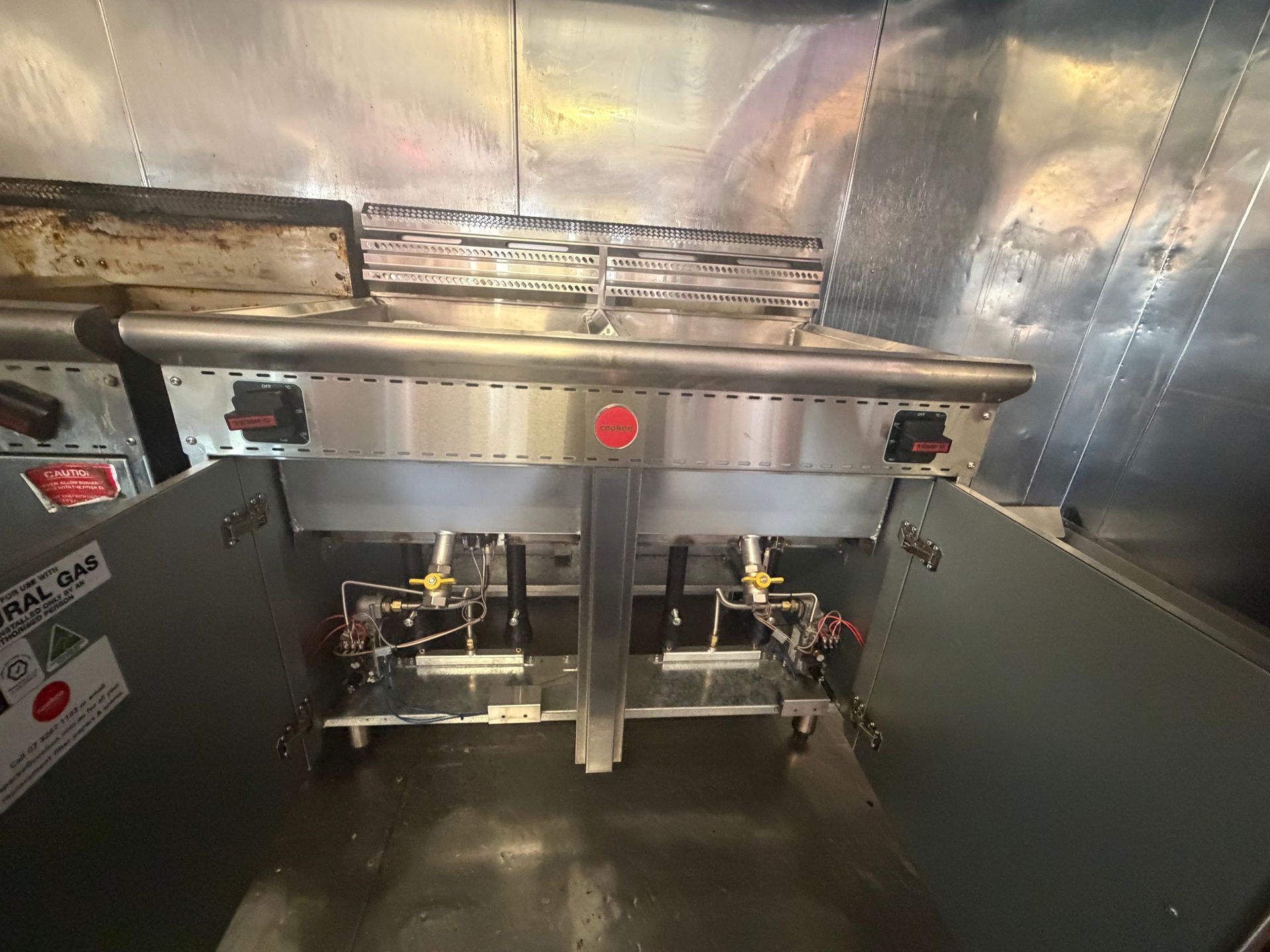 Interior of a stainless steel machine with a central panel, pipes, and red indicator lights — Truflow Plumbing & Gas Solutions in Rockhampton City, QLD