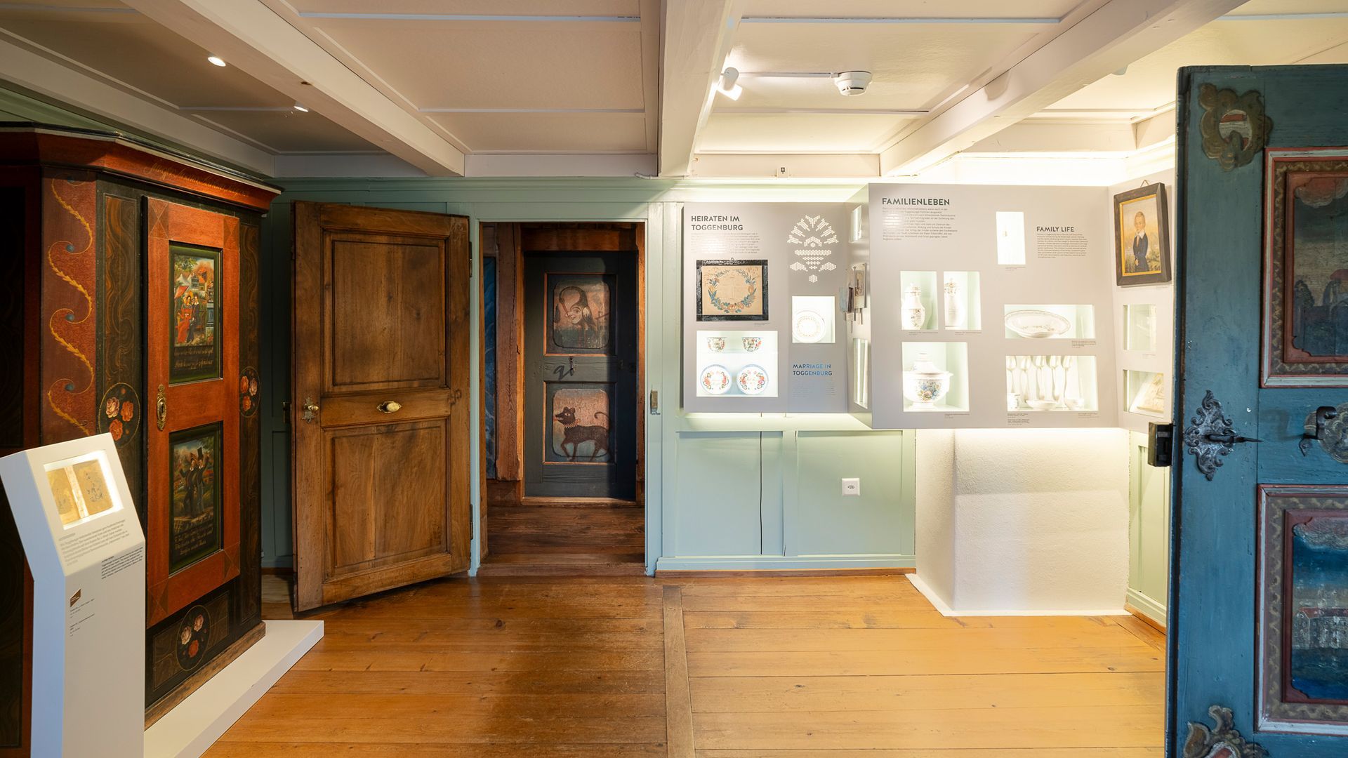 Ausstellungsraum im Museum Ackerhus mit historischen Möbeln, bemalten Türen und Einblicken in das Familienleben im Toggenburg