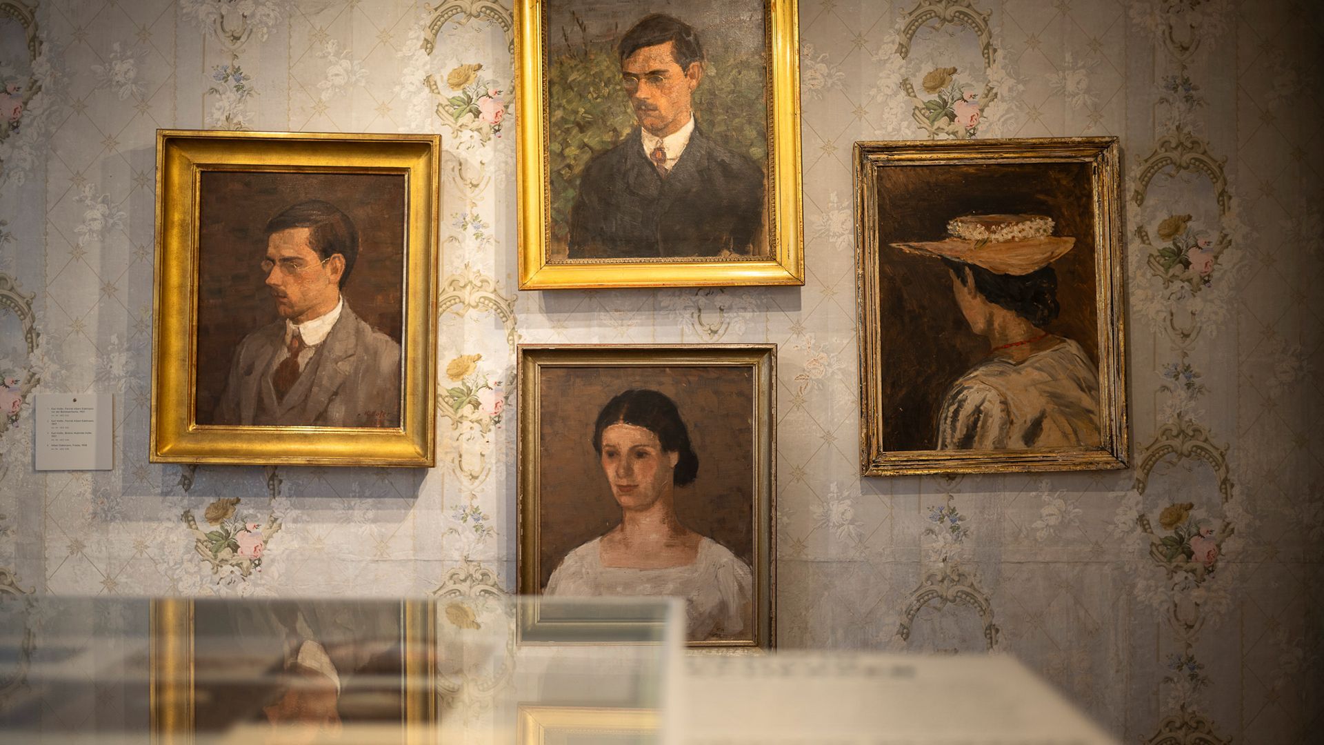 Porträtgemälde mit Darstellungen von Männern und Frauen in einer historischen Wohninszenierung im Museum Ackerhus