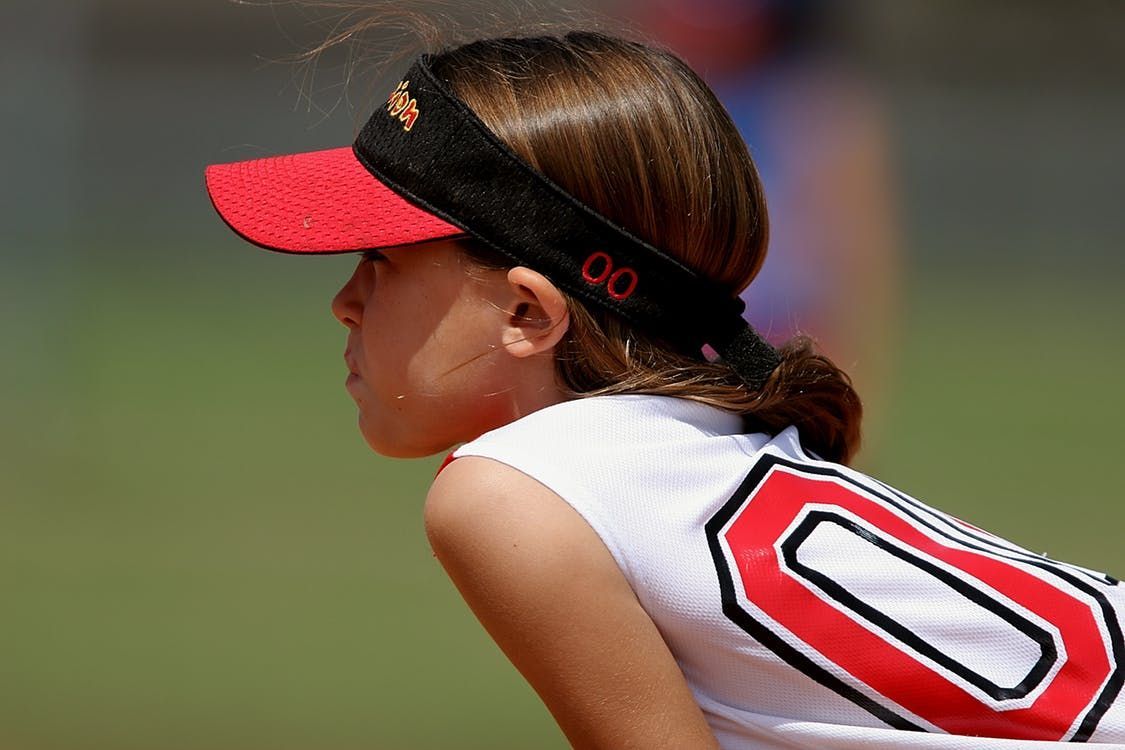 A girl wearing a visor and a jersey with the number 0 on it