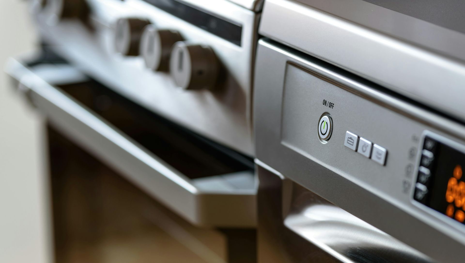 Silver kitchen oven and range with visible dials, buttons, and display.