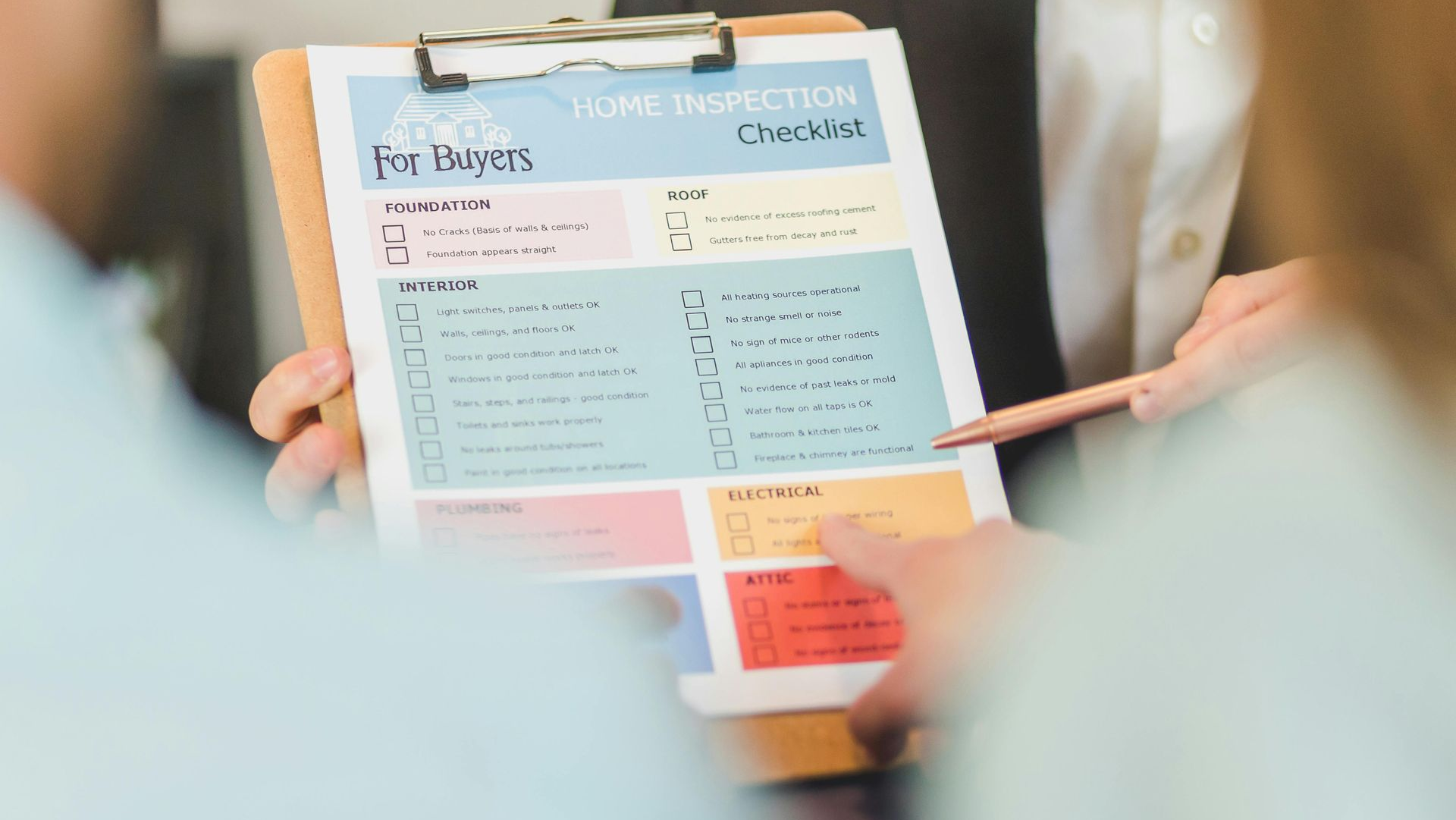 Person pointing at a home inspection checklist on a clipboard.