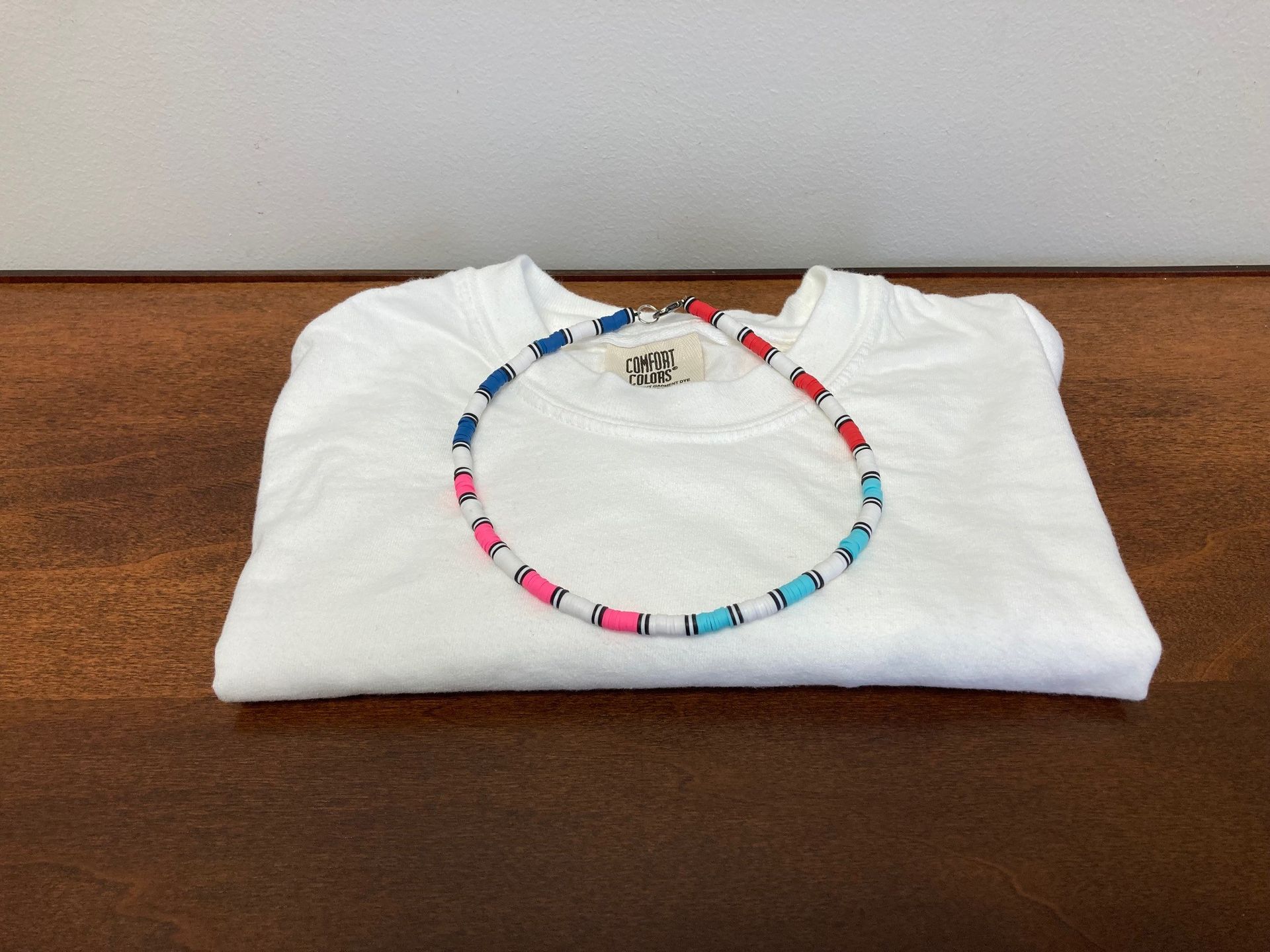 Colorful beaded bracelet on folded white cloth on a wooden surface