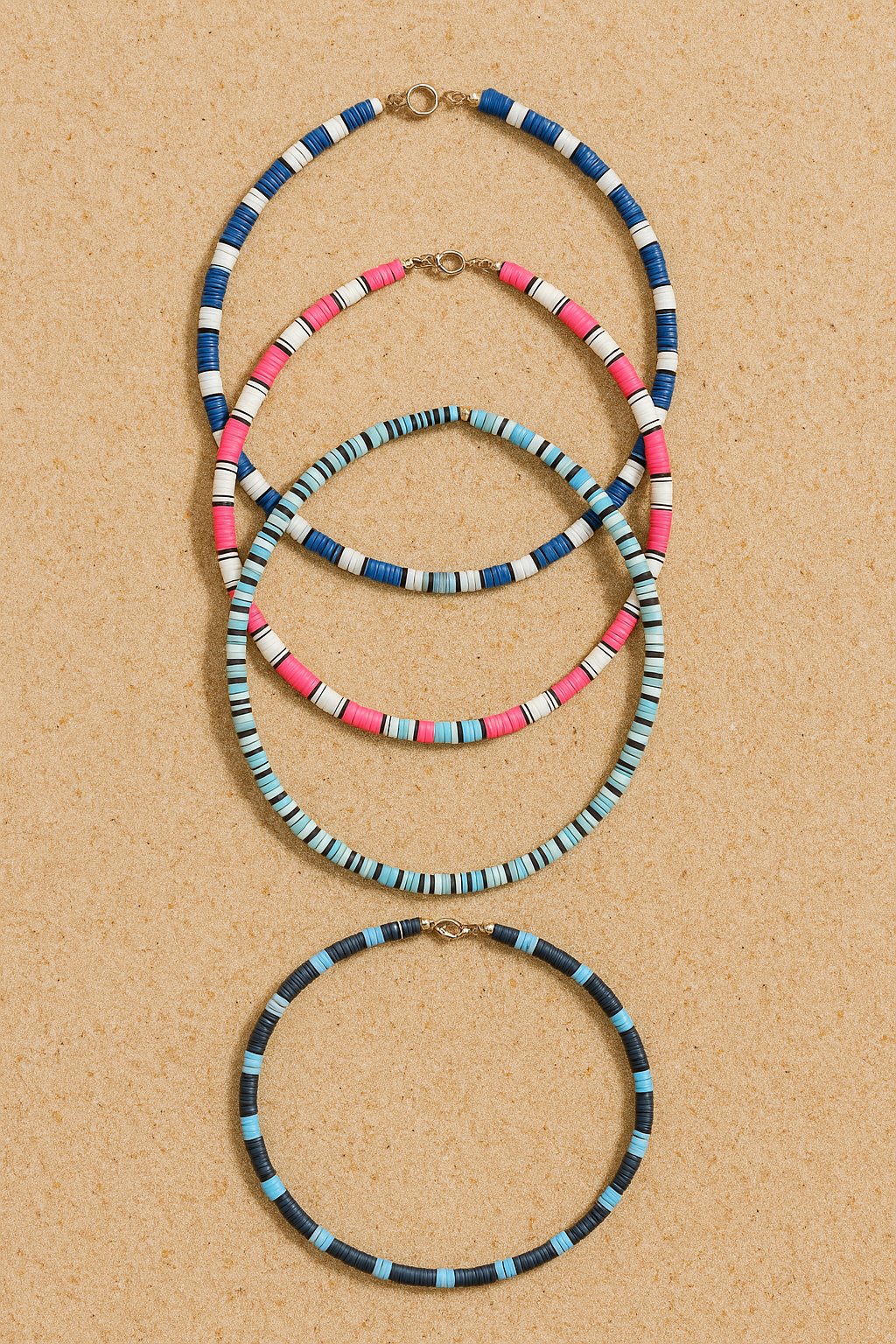 Four overlapping beaded bracelets in blue, pink, and tan on a beige background