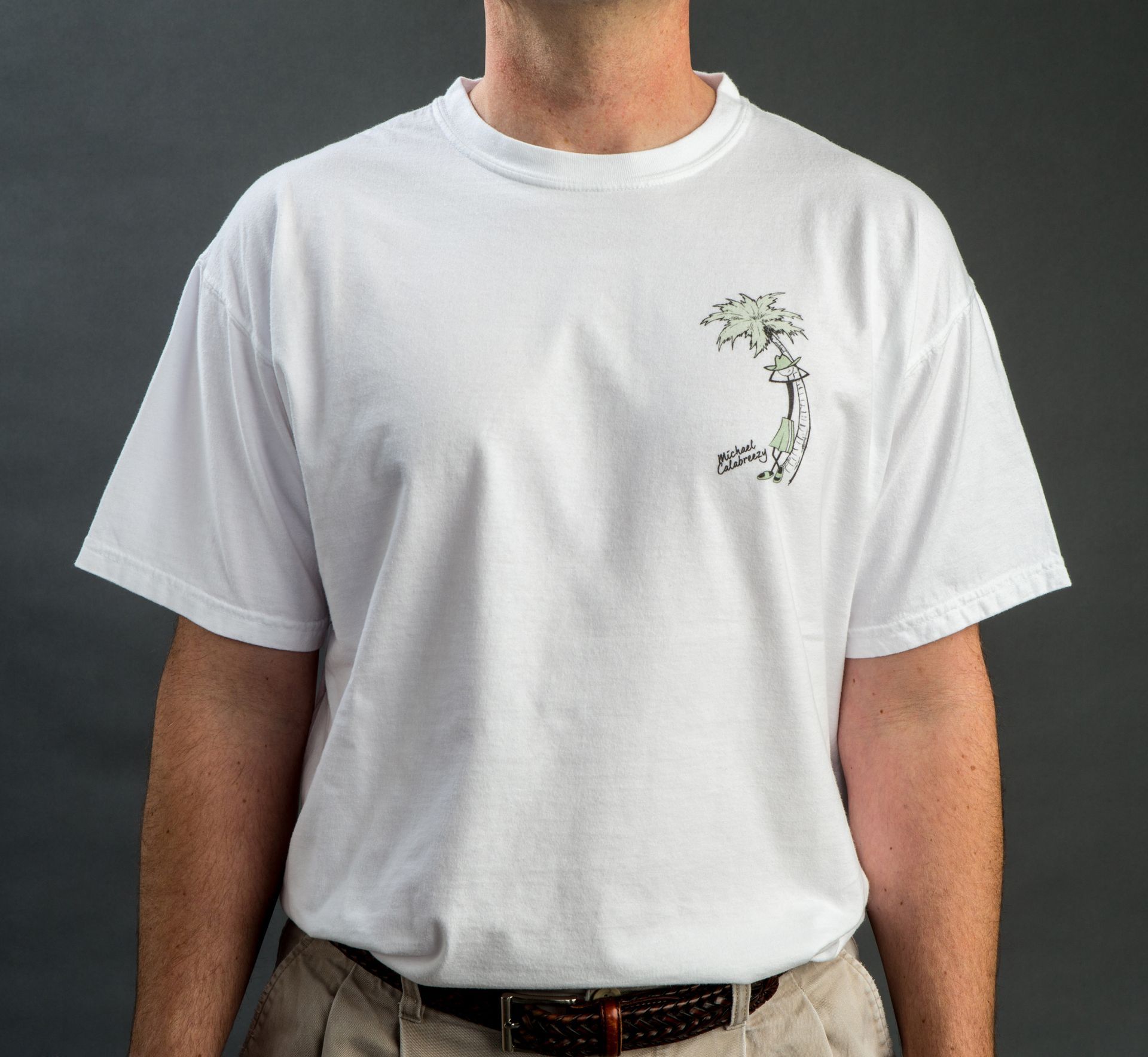 Person wearing a white T-shirt with a small floral graphic on the chest.