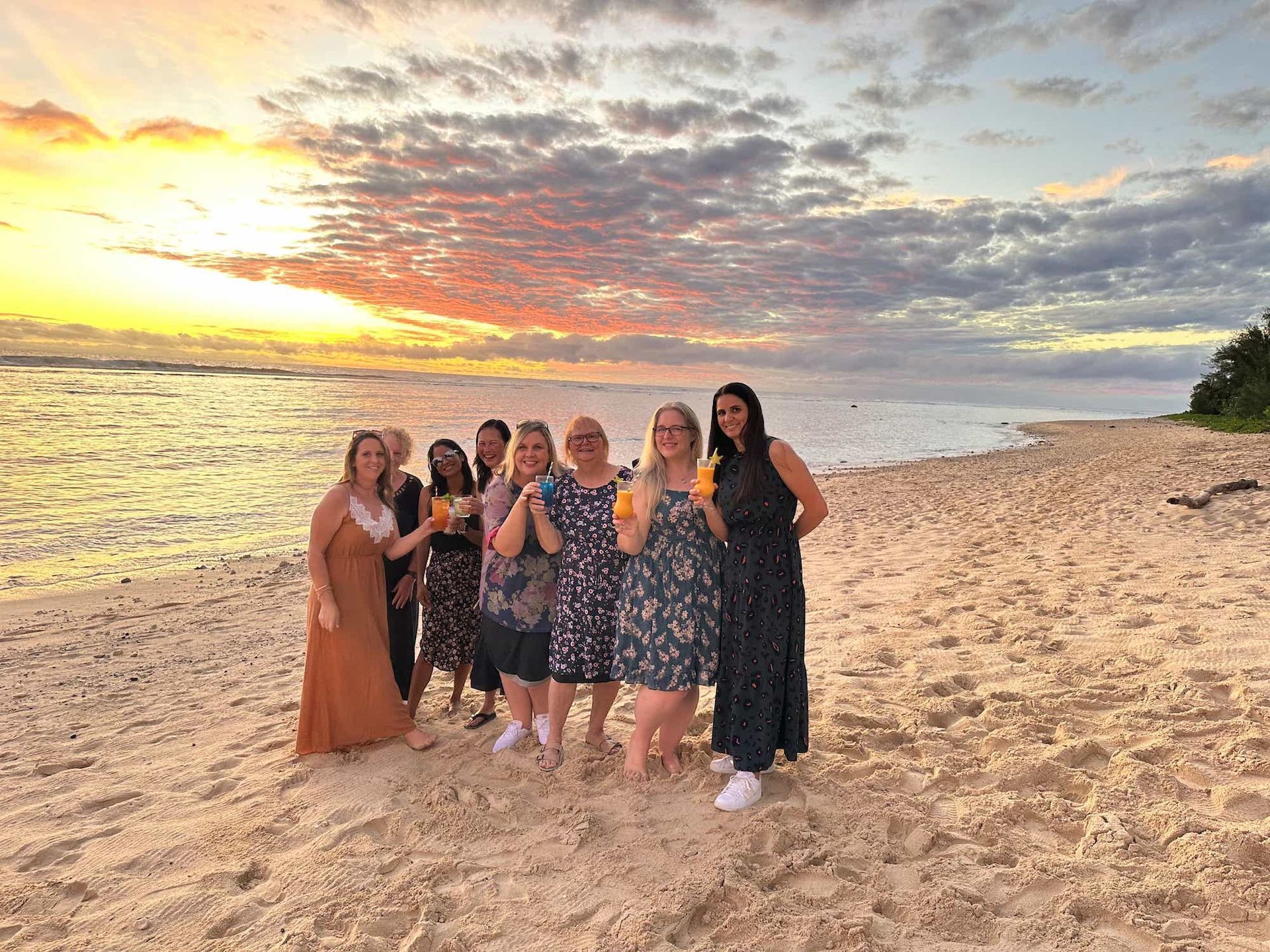 NOWW women saying 'cheers' on the beach
