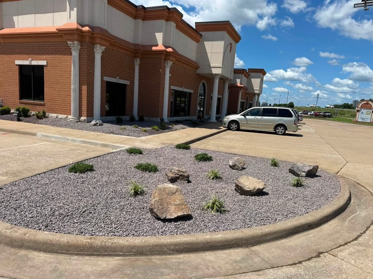 Brick building entrance with desert landscaping and a white SUV parked nearby