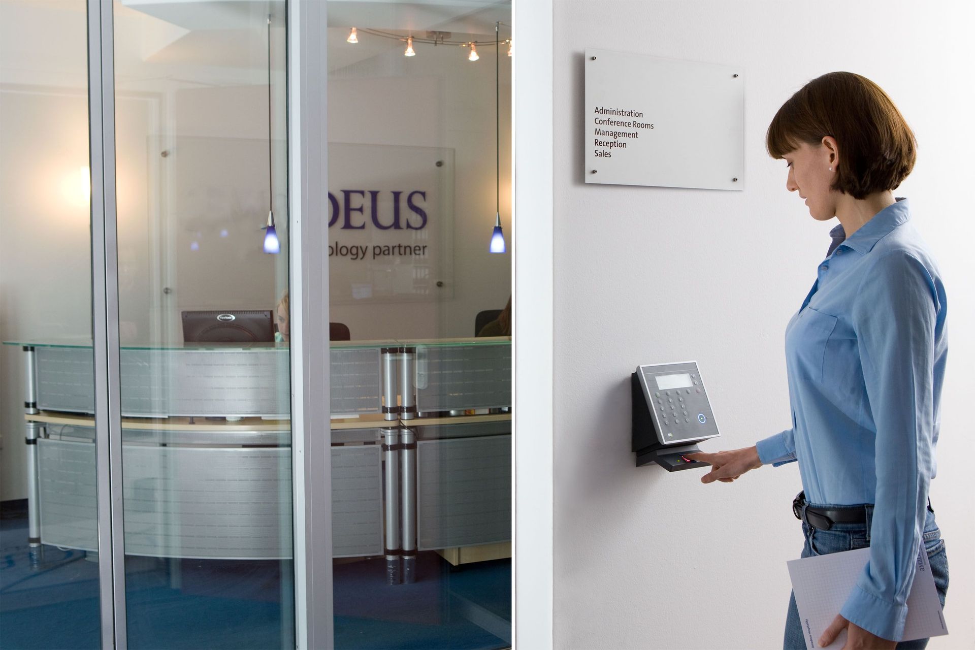 Woman using a wall-mounted touchscreen at an office entrance with glass doors
