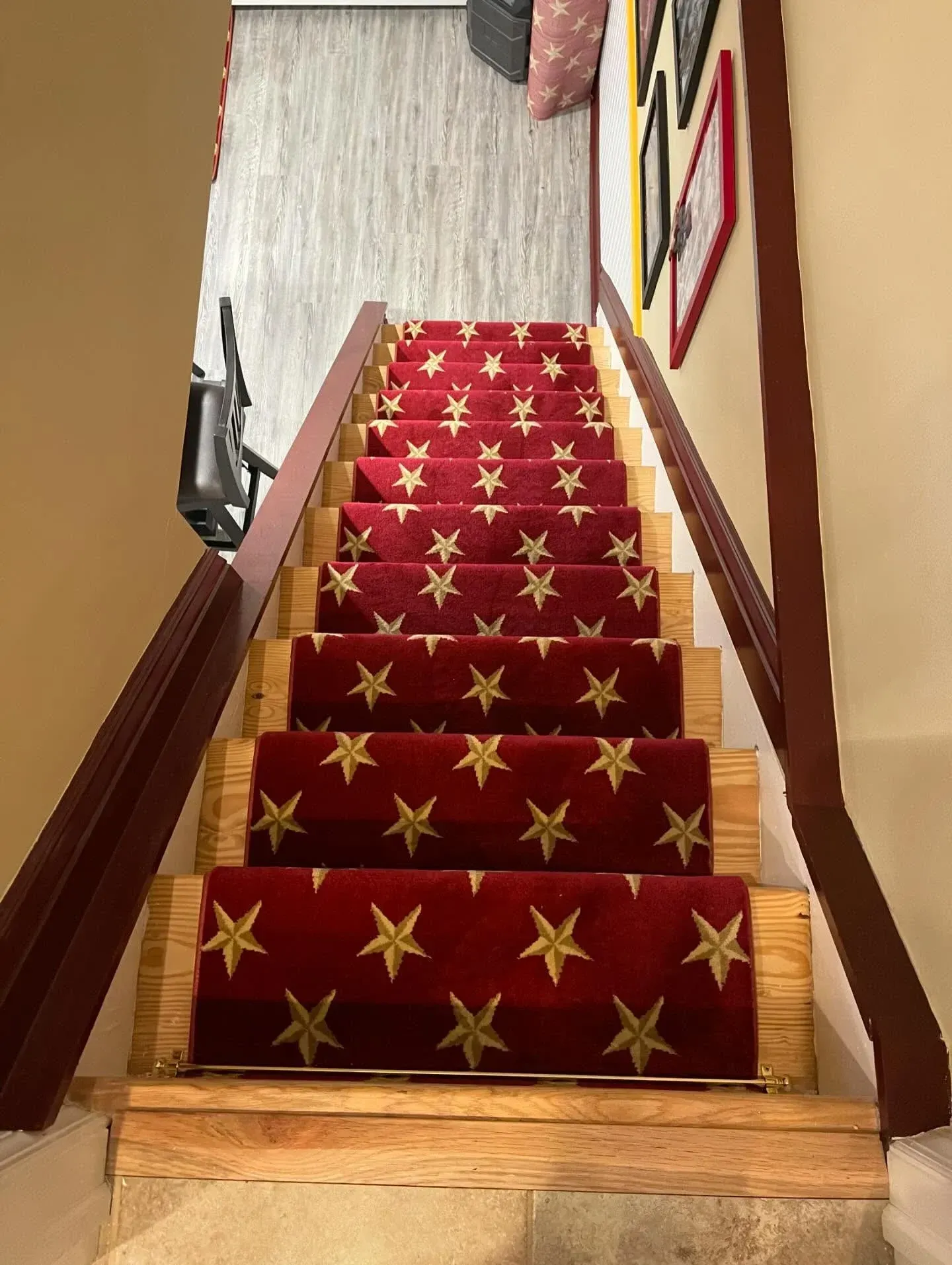 Red-carpeted staircase with gold star pattern, viewed from the top indoors.