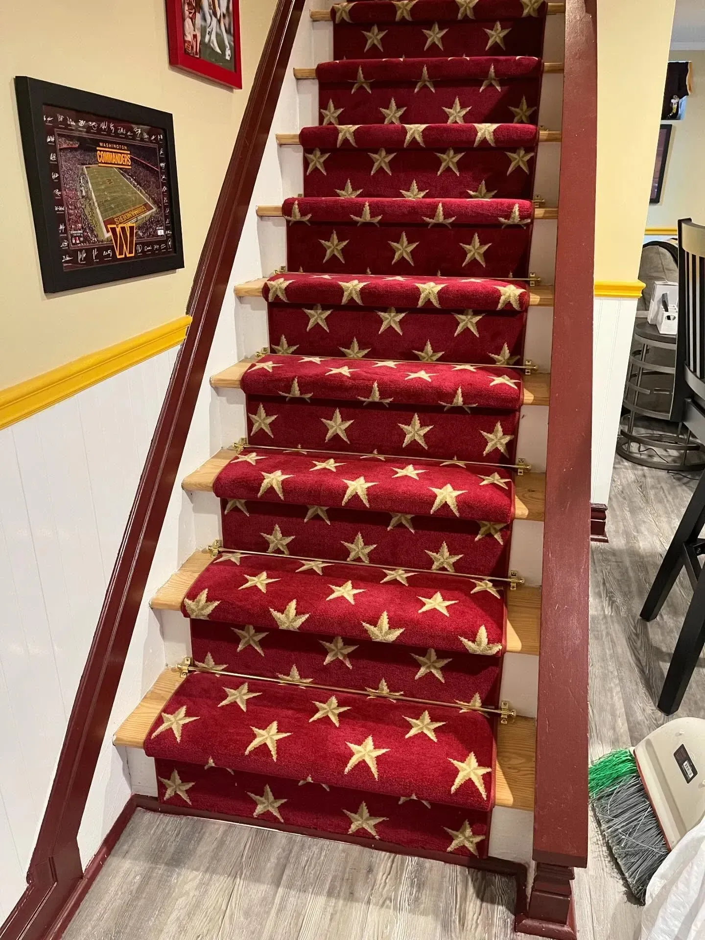 Indoor staircase with red star-pattern carpet runner and wooden handrails in a home setting