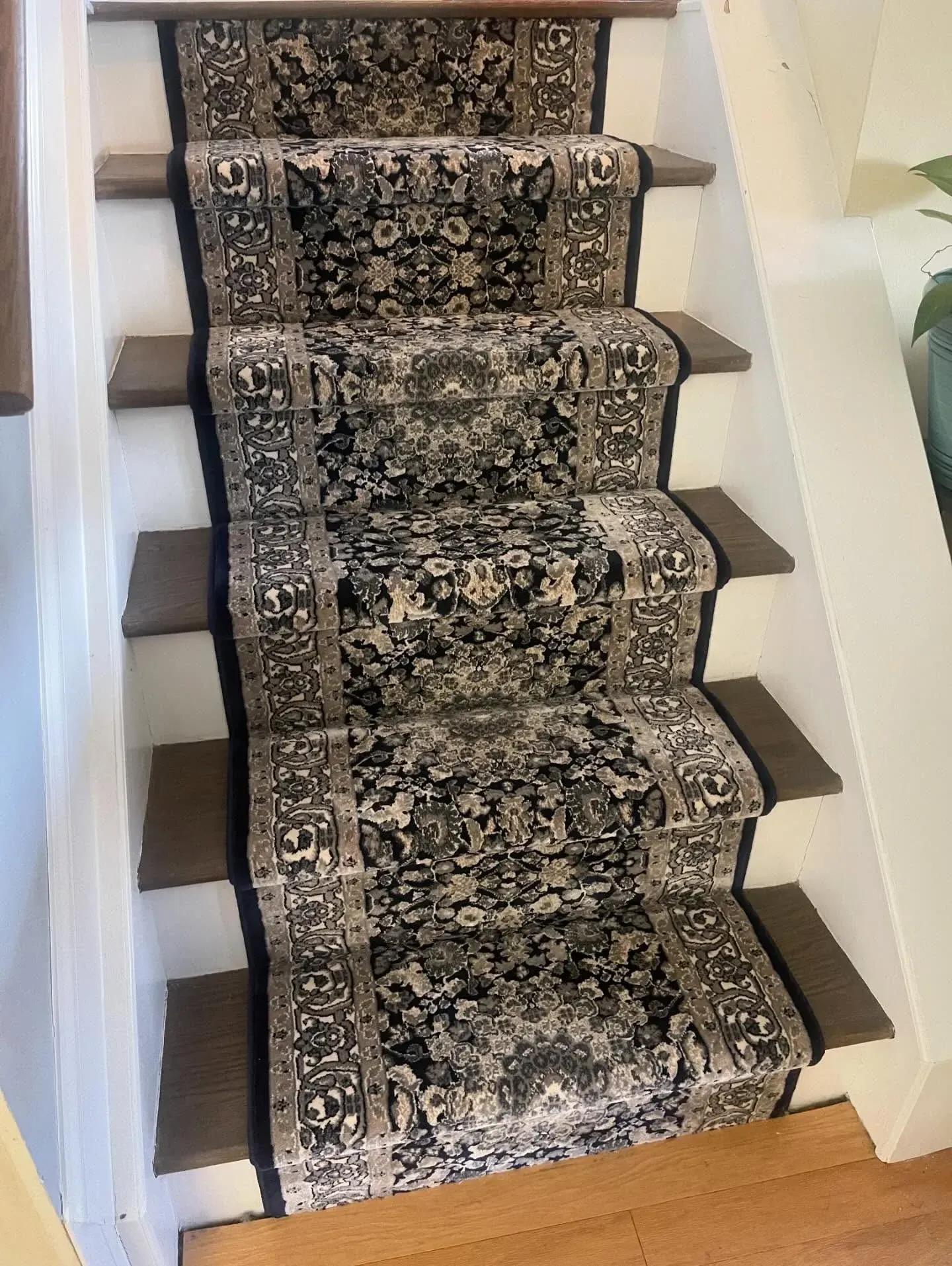 Patterned runner rug on a carpeted staircase in a home interior