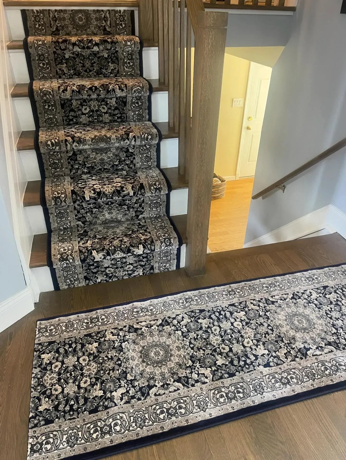Carpeted staircase and hallway with patterned runner rugs in a home interior