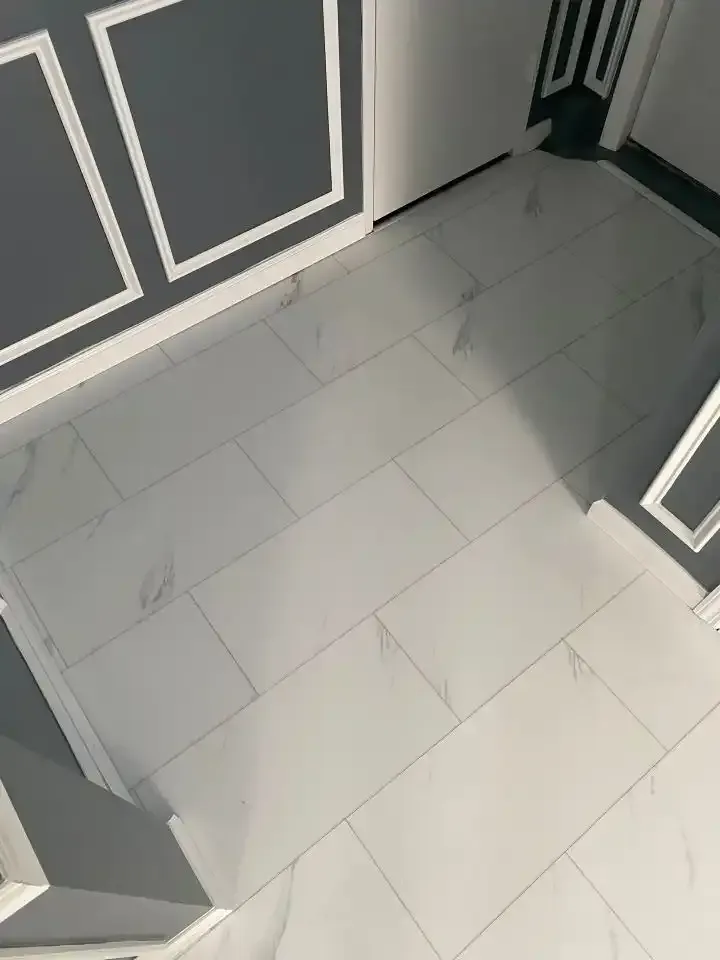 White tiled hallway floor with gray paneled walls and an open door.