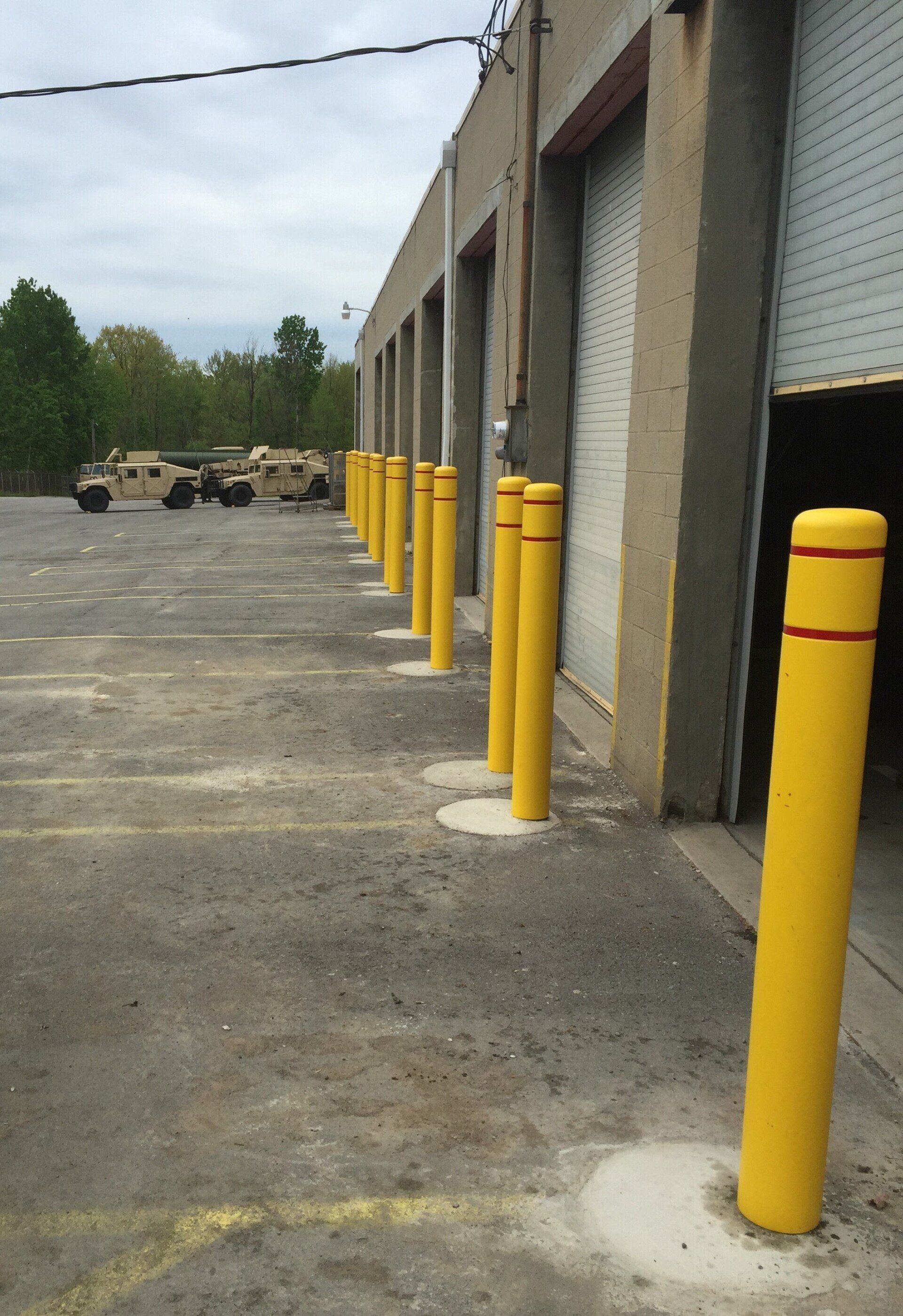 Bullards installed in front of a warehouse building from Metal Fence Supply Co.