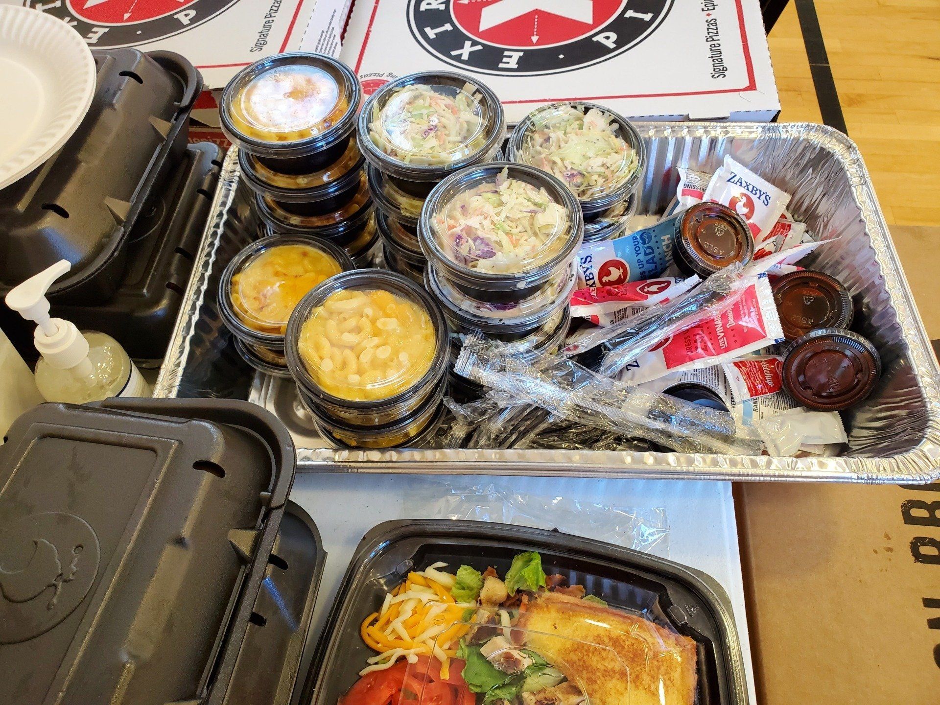 A table topped with containers of food and condiments.