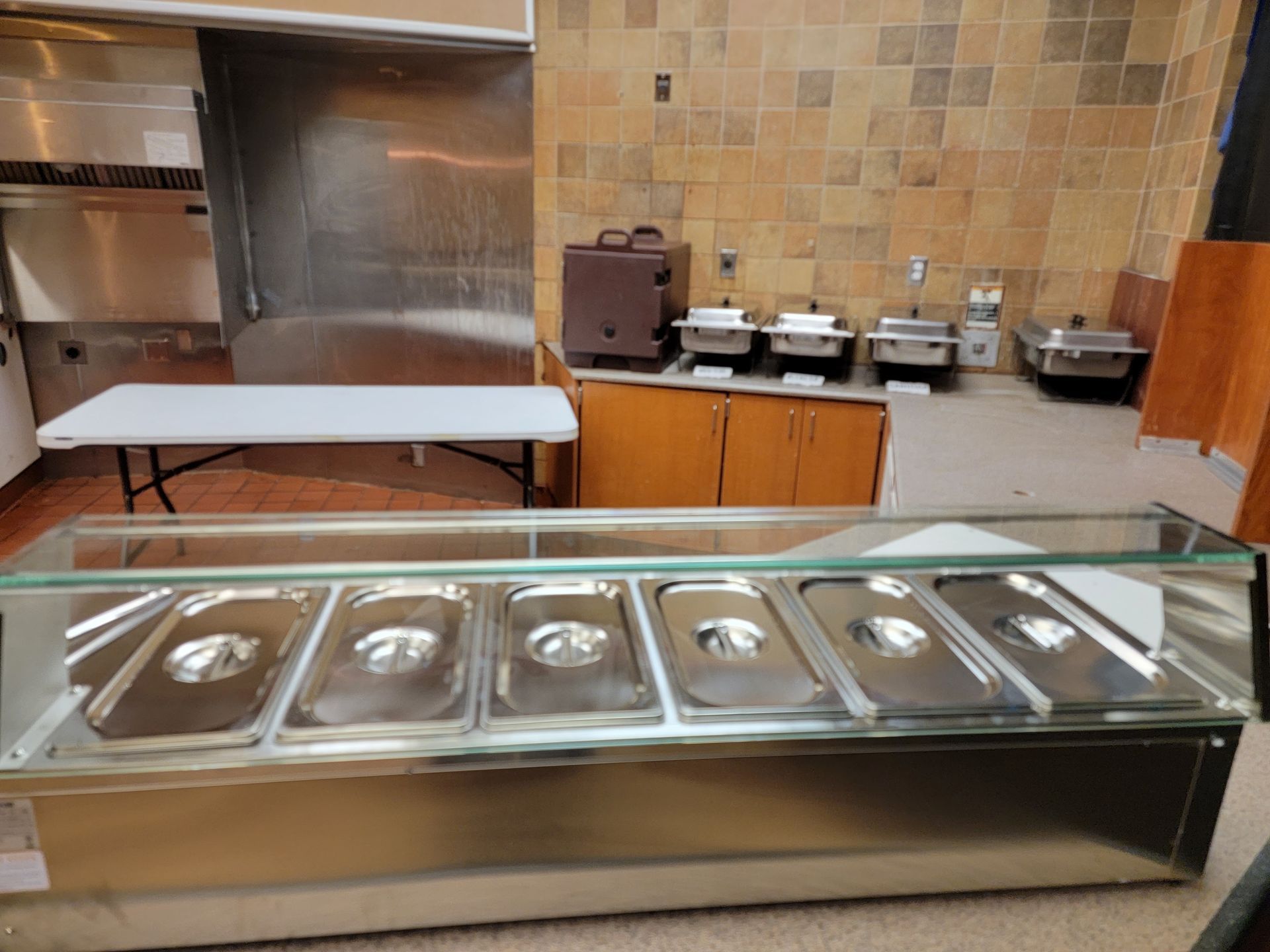 A kitchen with stainless steel containers and a table