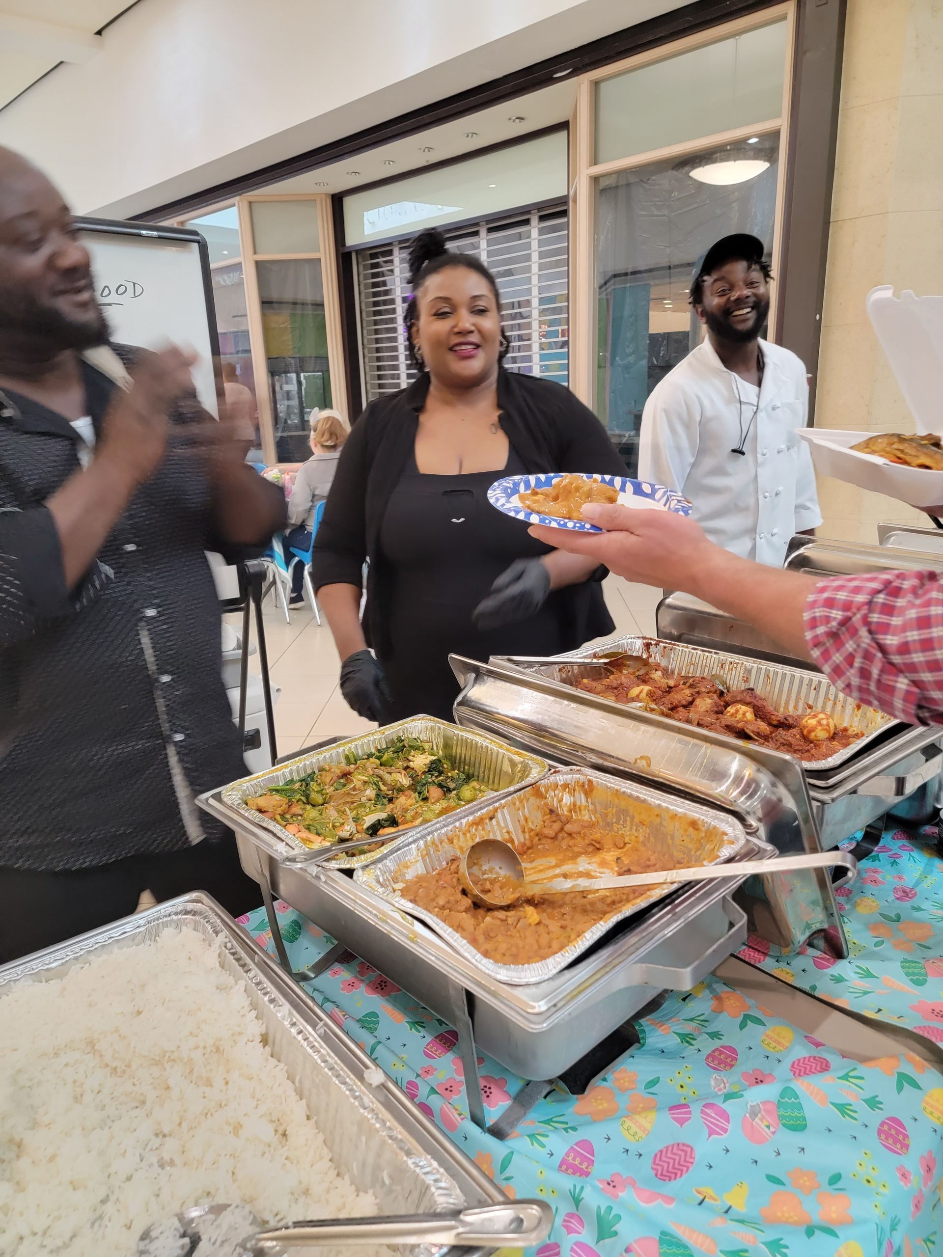 A woman is holding a plate of food in front of a buffet table.