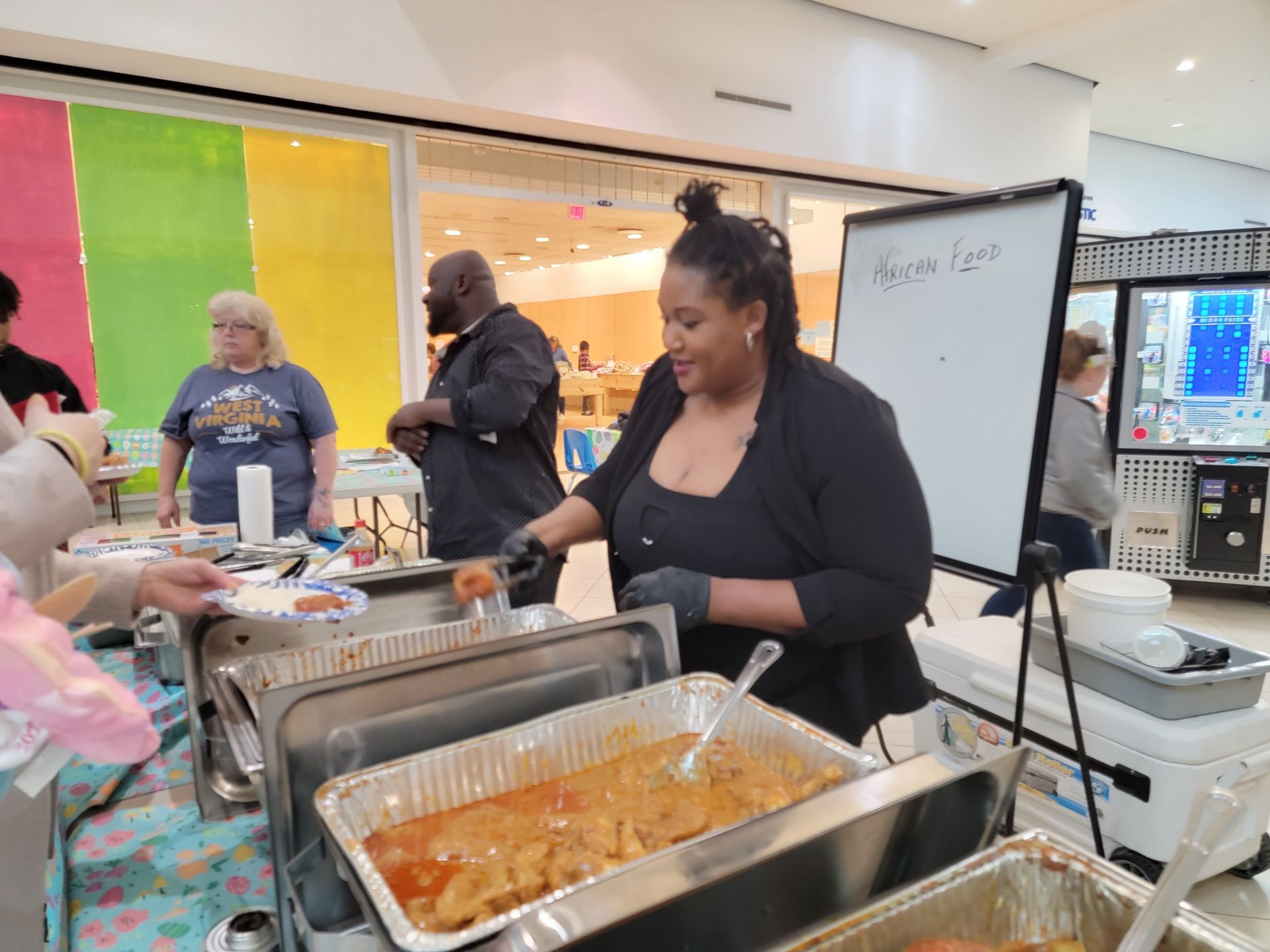 A woman is serving food at a buffet table.