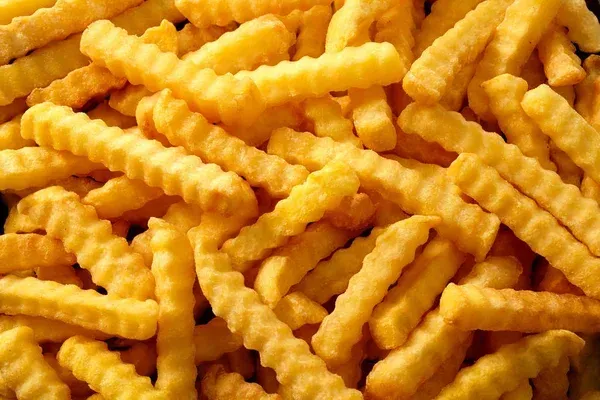 A pile of french fries is sitting on a table.
