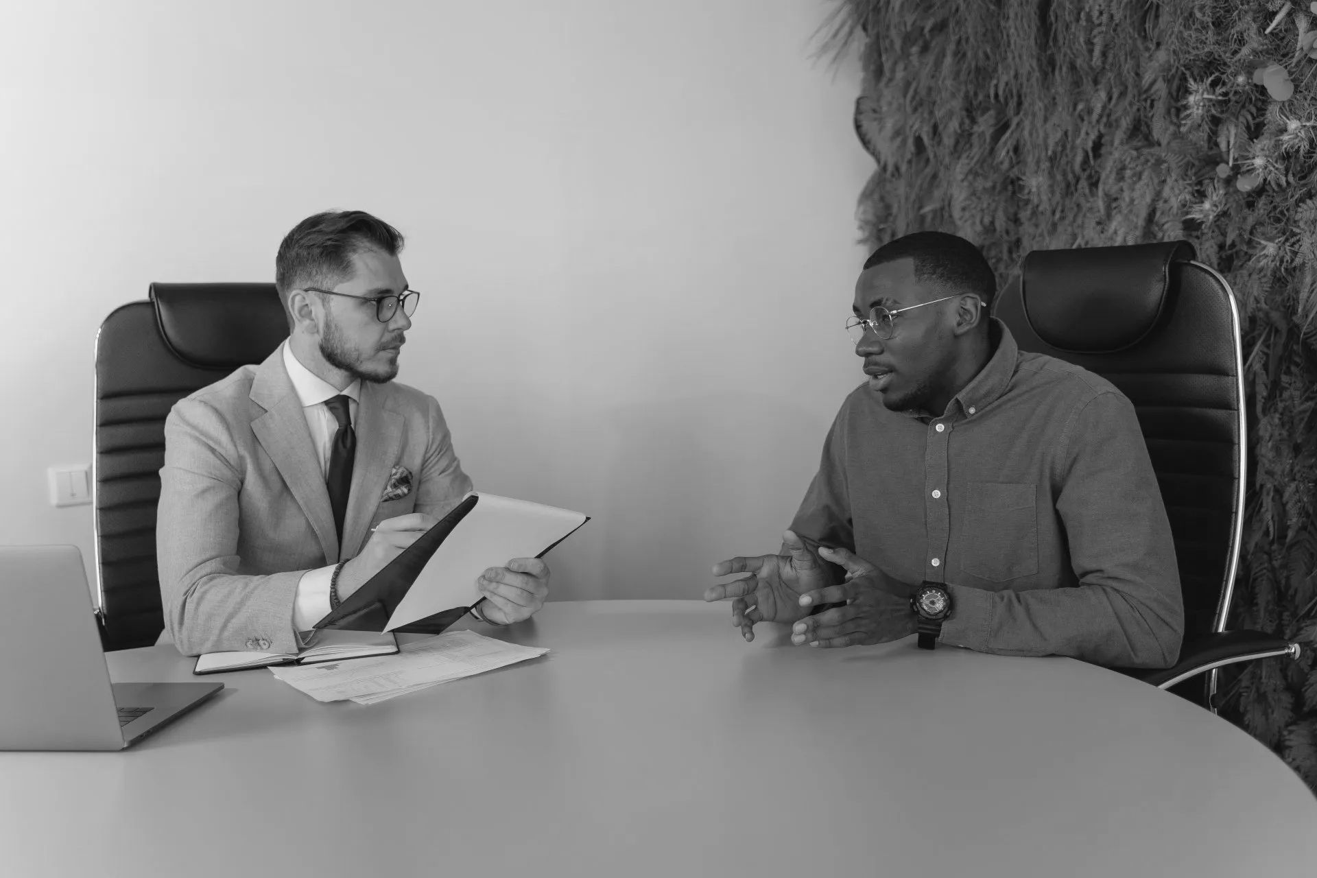 Two men are sitting at a table having a conversation.