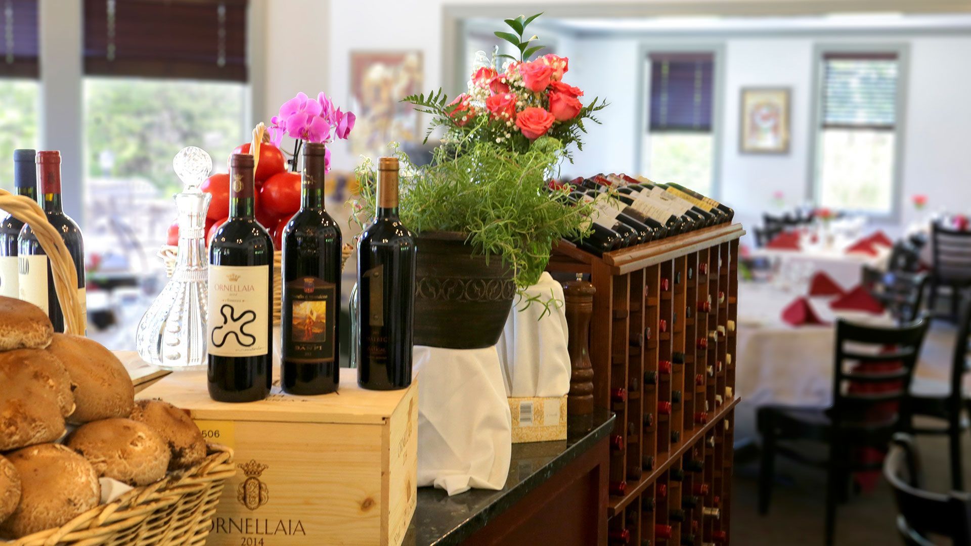A row of wine bottles sitting on top of a counter in a restaurant.