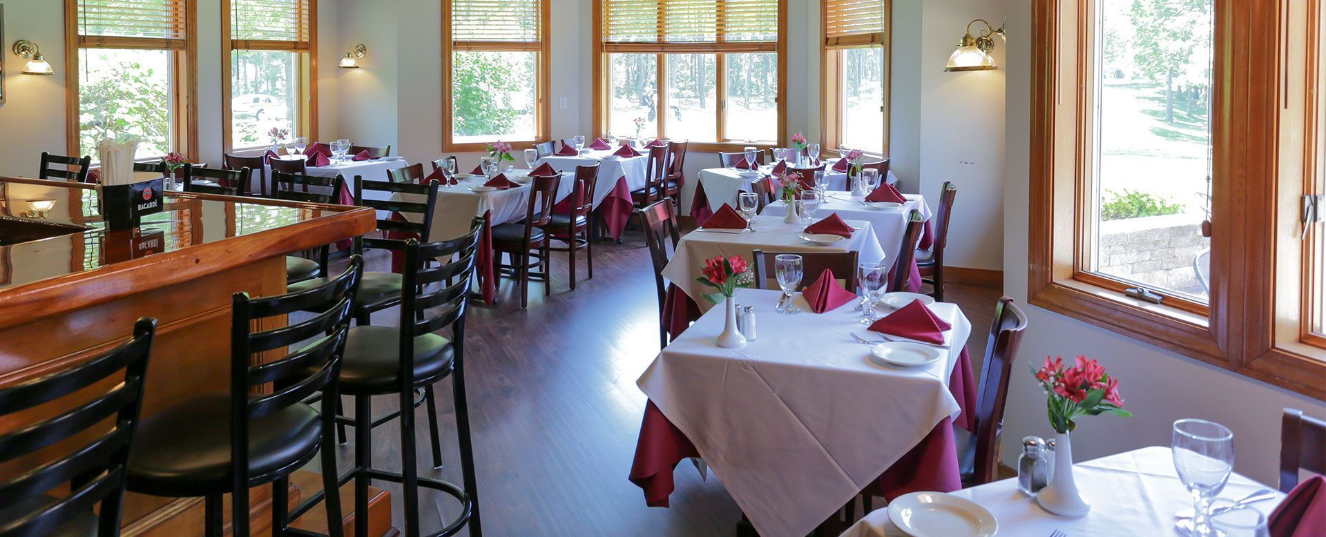 A large dining room with tables and chairs and a bar