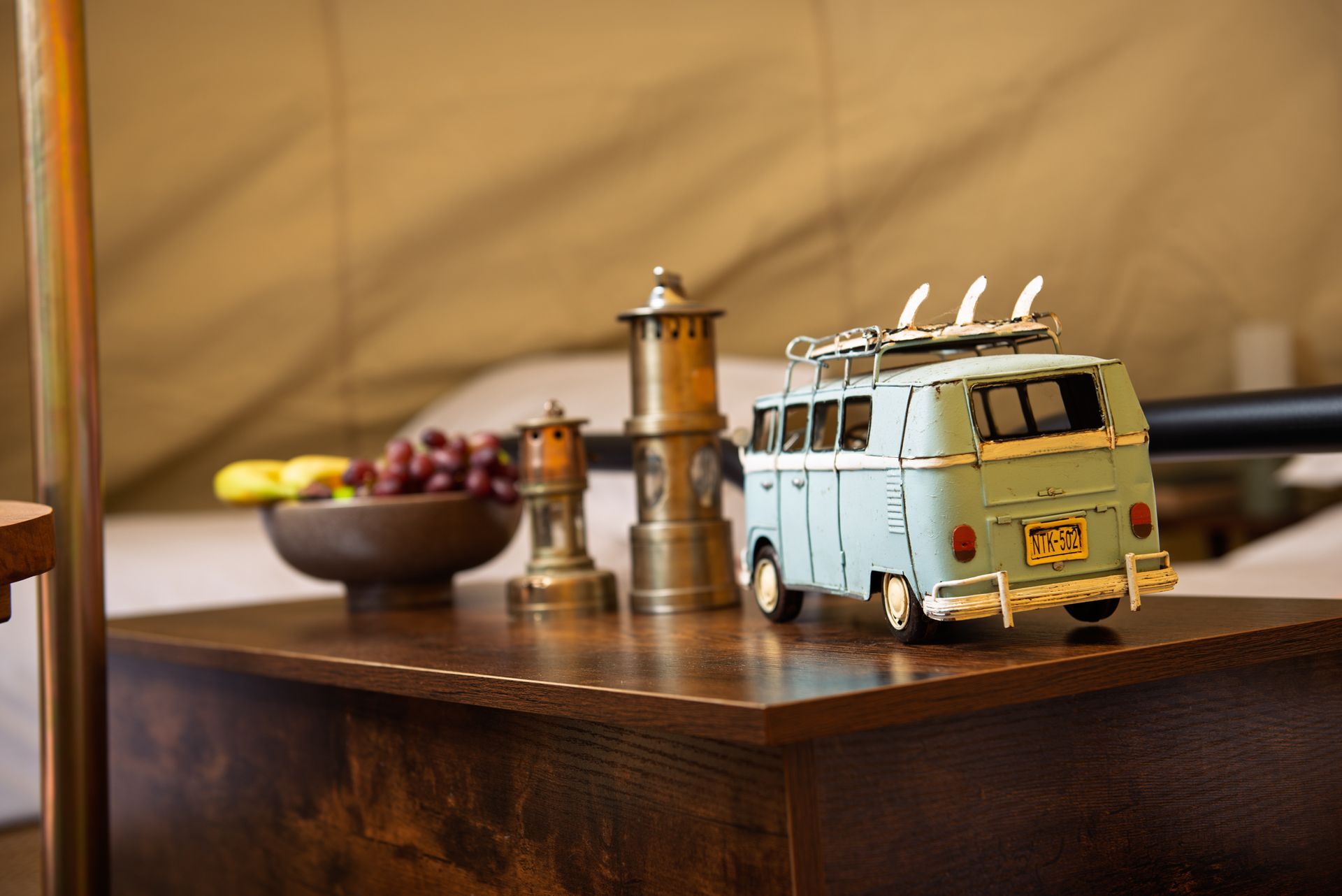 Vintage light blue toy van on a wooden table with bowls and decor in the background