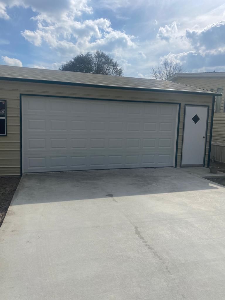A garage with a white garage door and a white door.