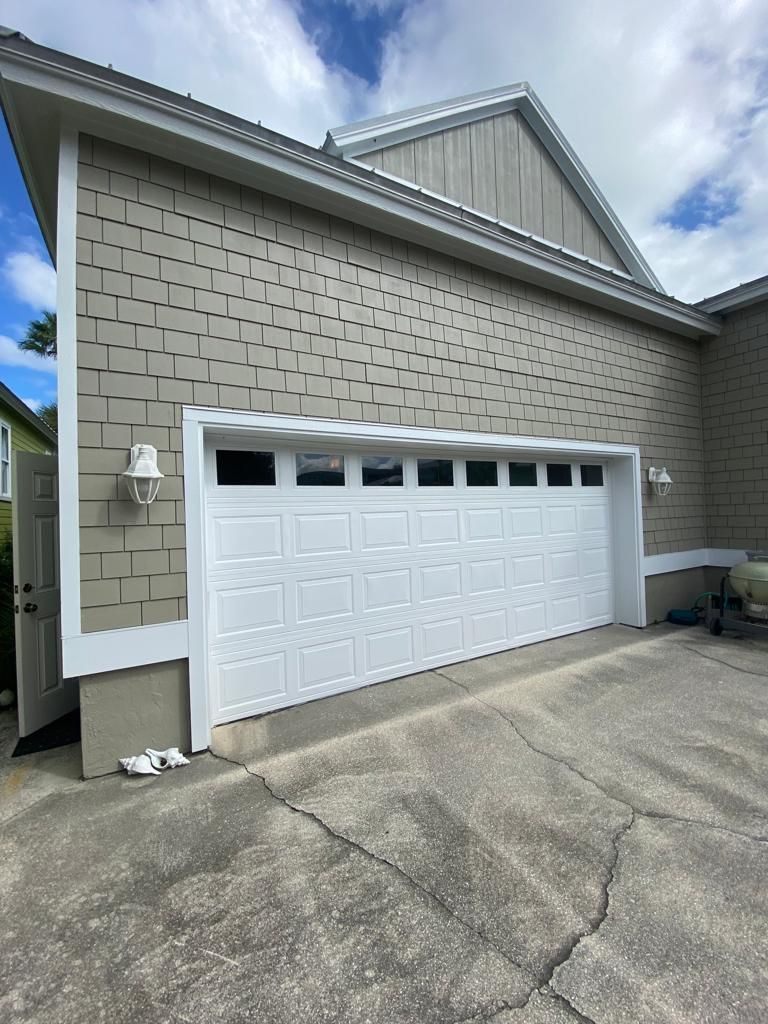 A large white garage door is on the side of a house.