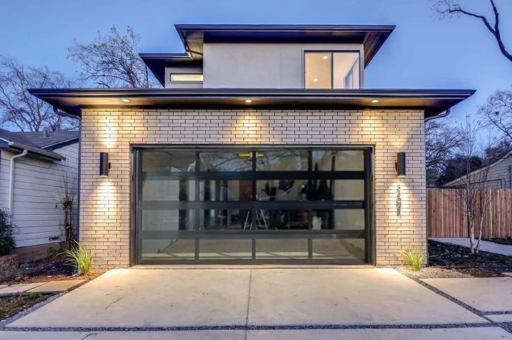 A modern house with a large glass garage door.