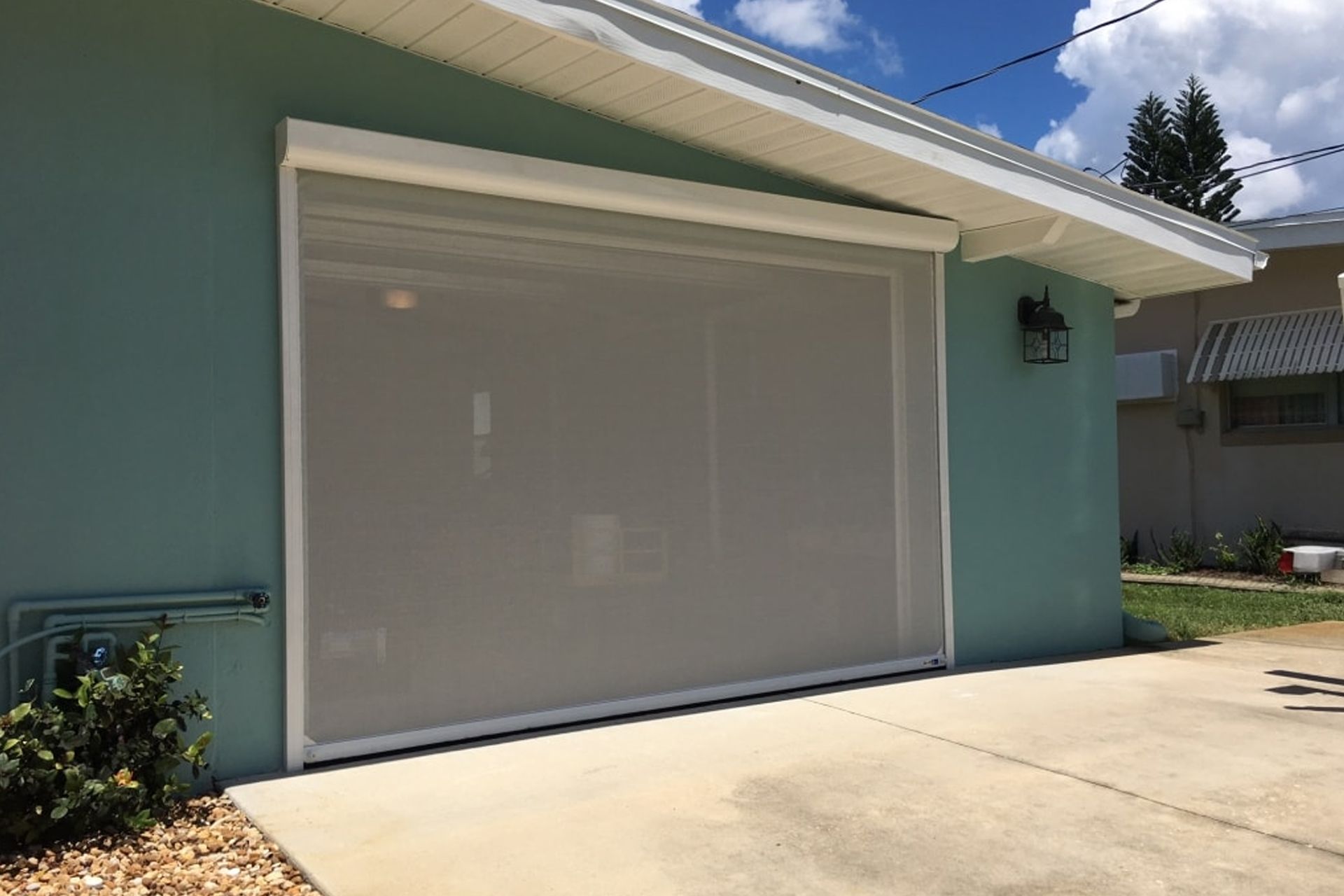 A house with a garage door with a screen on it.
