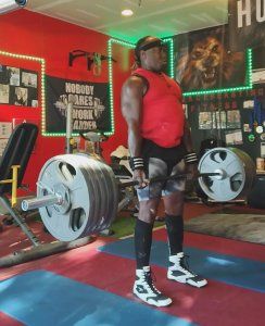 A man is lifting a barbell in a gym.