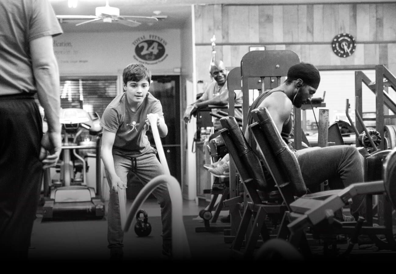 A man is doing push ups in a gym in a black and white photo.