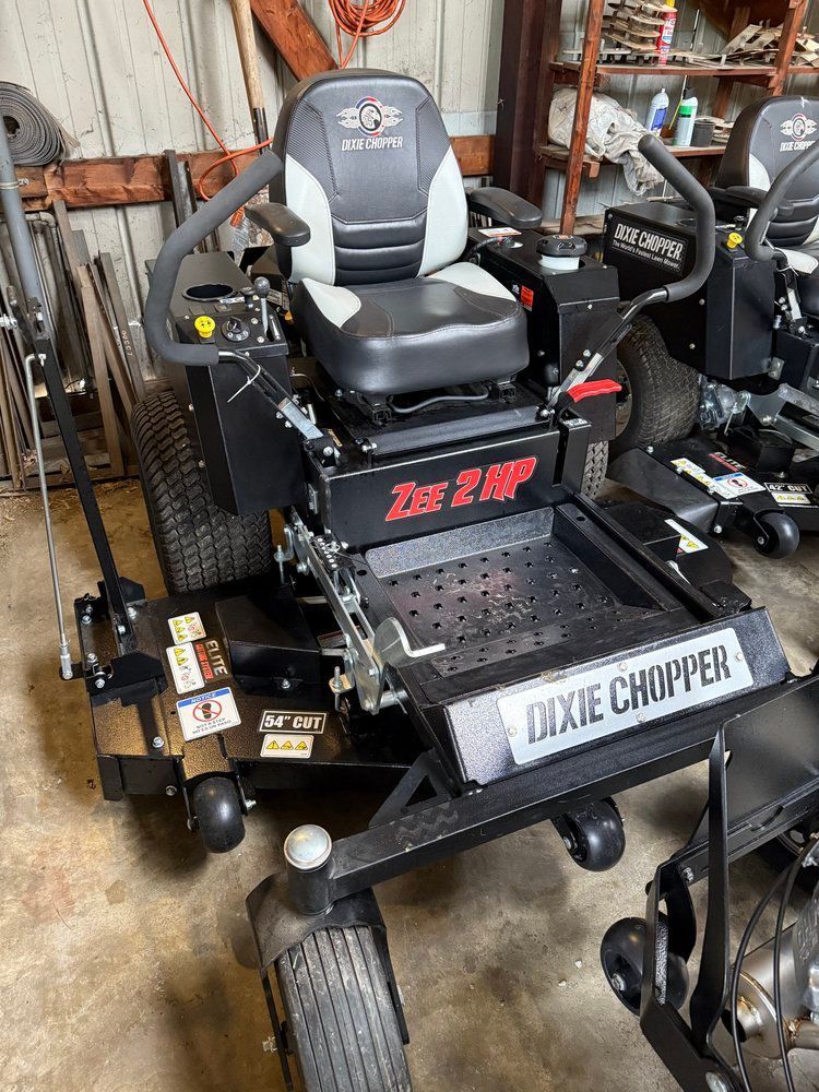 Black and gray Dixie Chopper zero-turn lawnmower with a seat and controls, indoors.