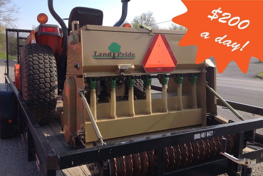 Tractor with a Land Pride seeder on a trailer; orange price tag says 