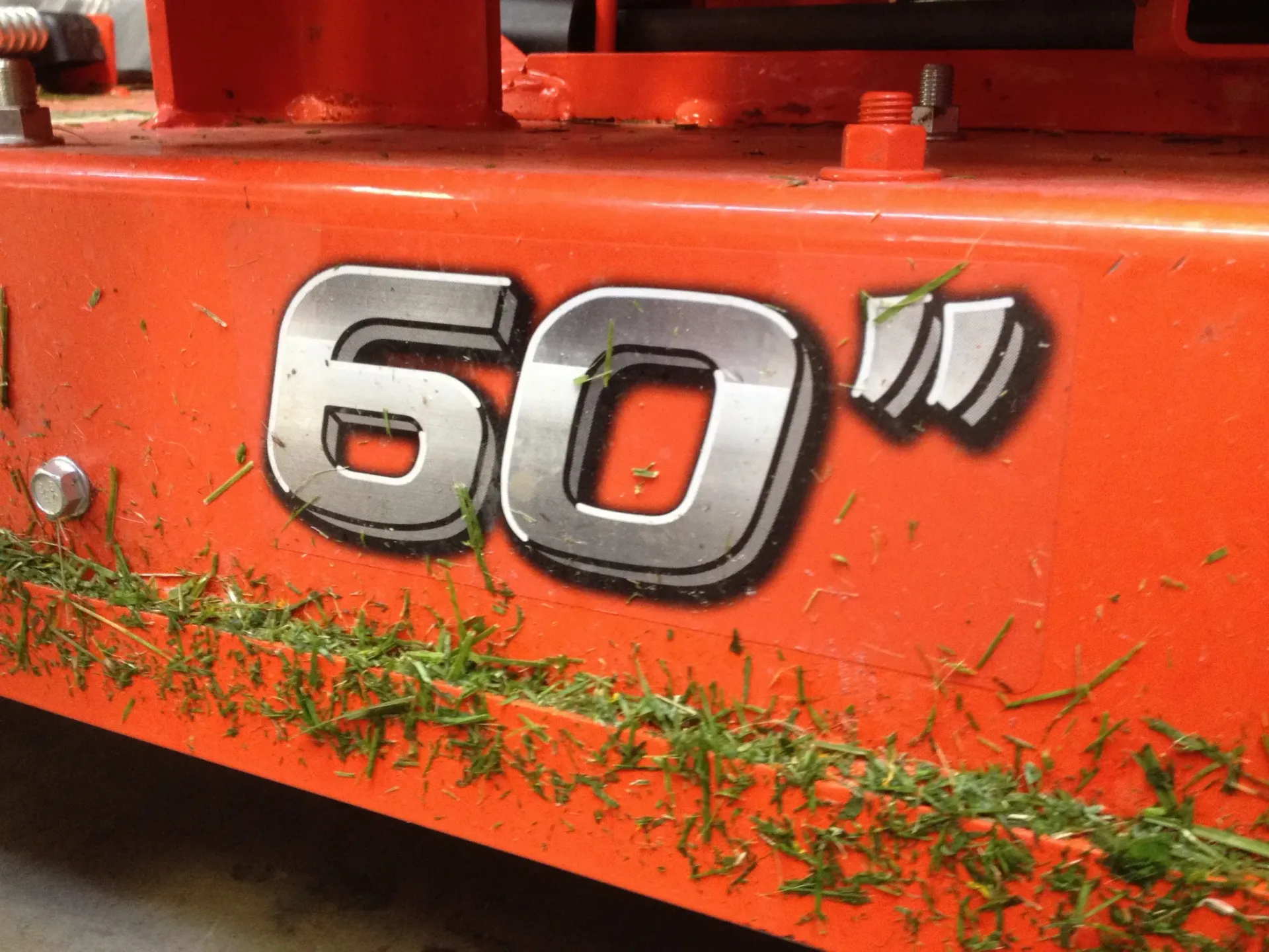 Close-up of an orange lawnmower deck. The number 